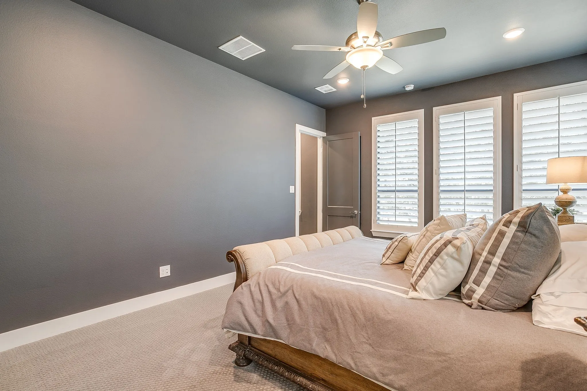 Large primary bedroom with plantation shutters.