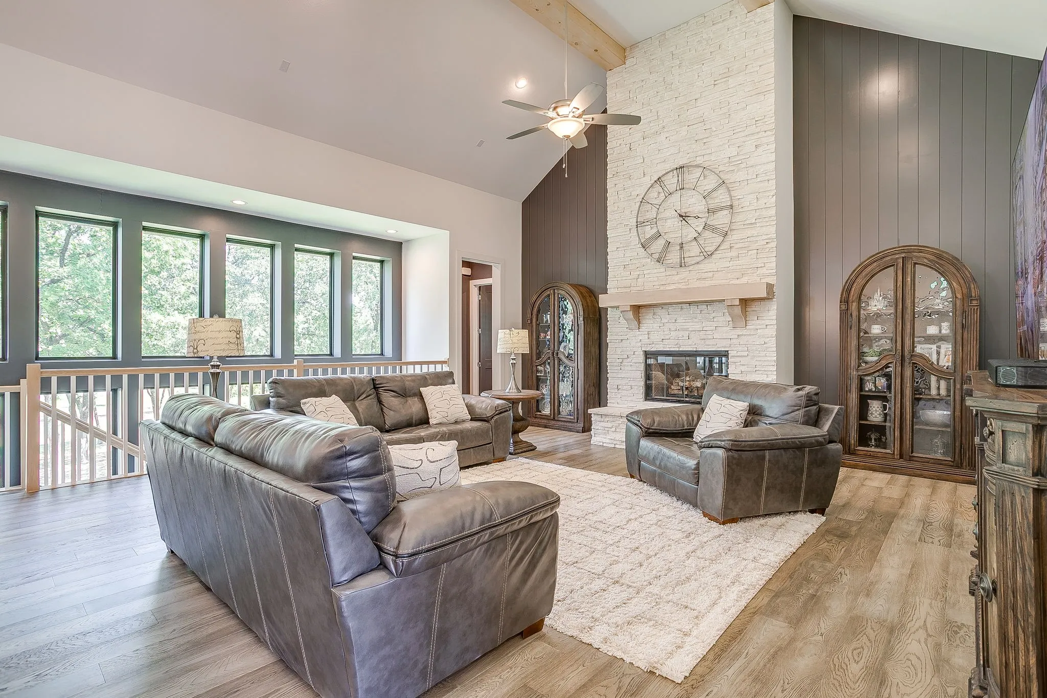 Beautiful living room wit floor-to-ceiling, stone fireplace.