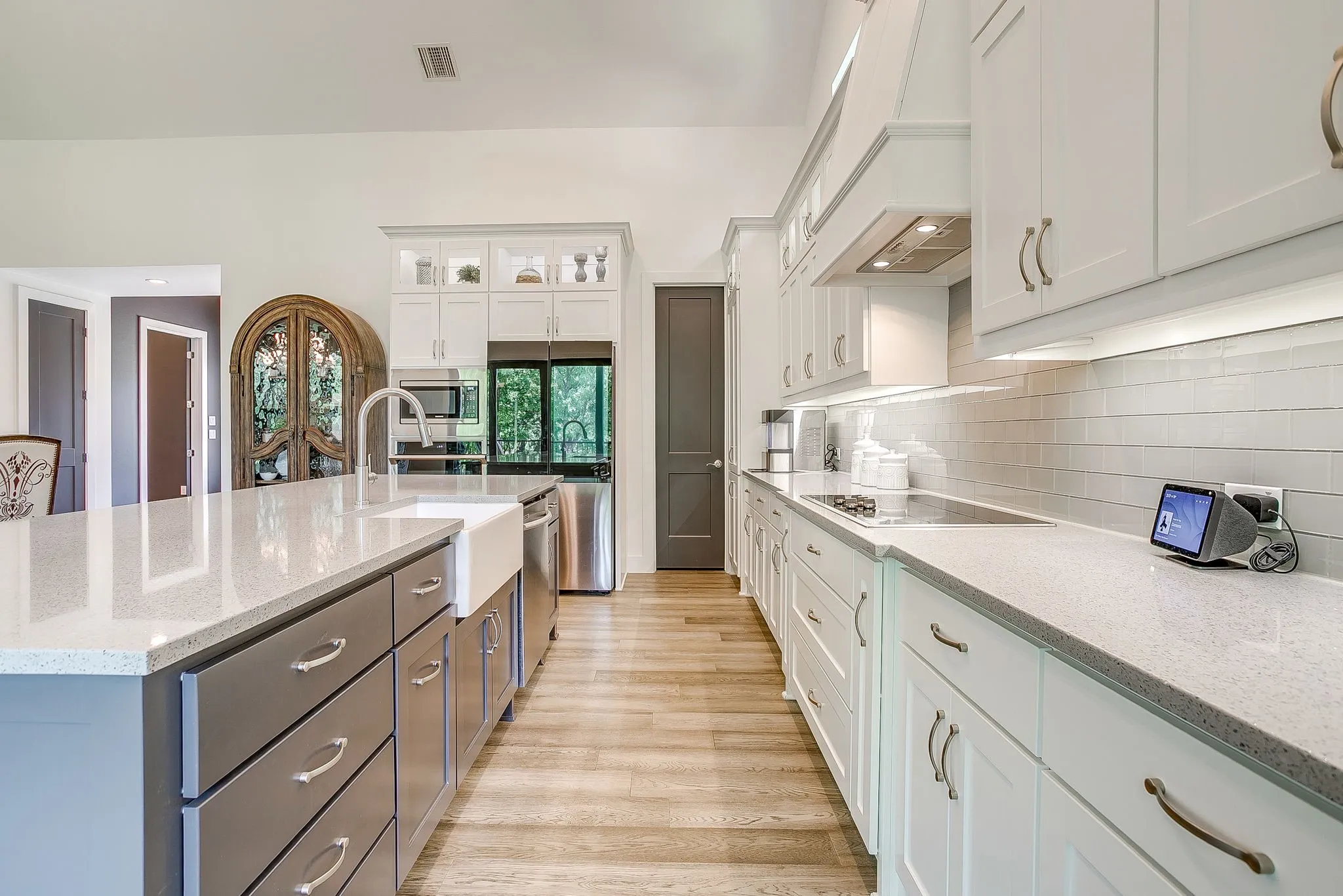 Kitchen with quartz countertops & tiled backsplash.