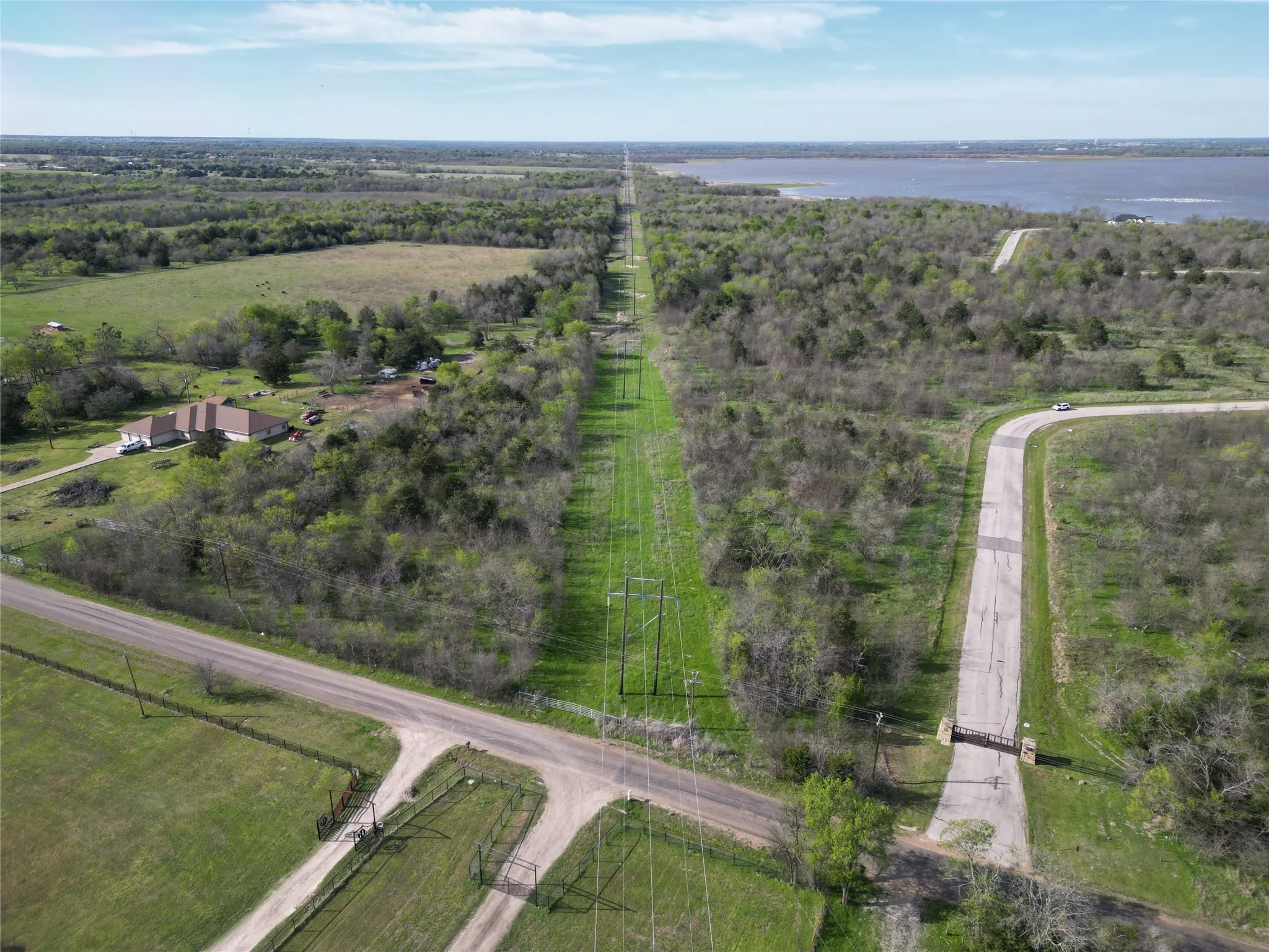 Expansive land parcel with direct road access and a visible water body in the distance