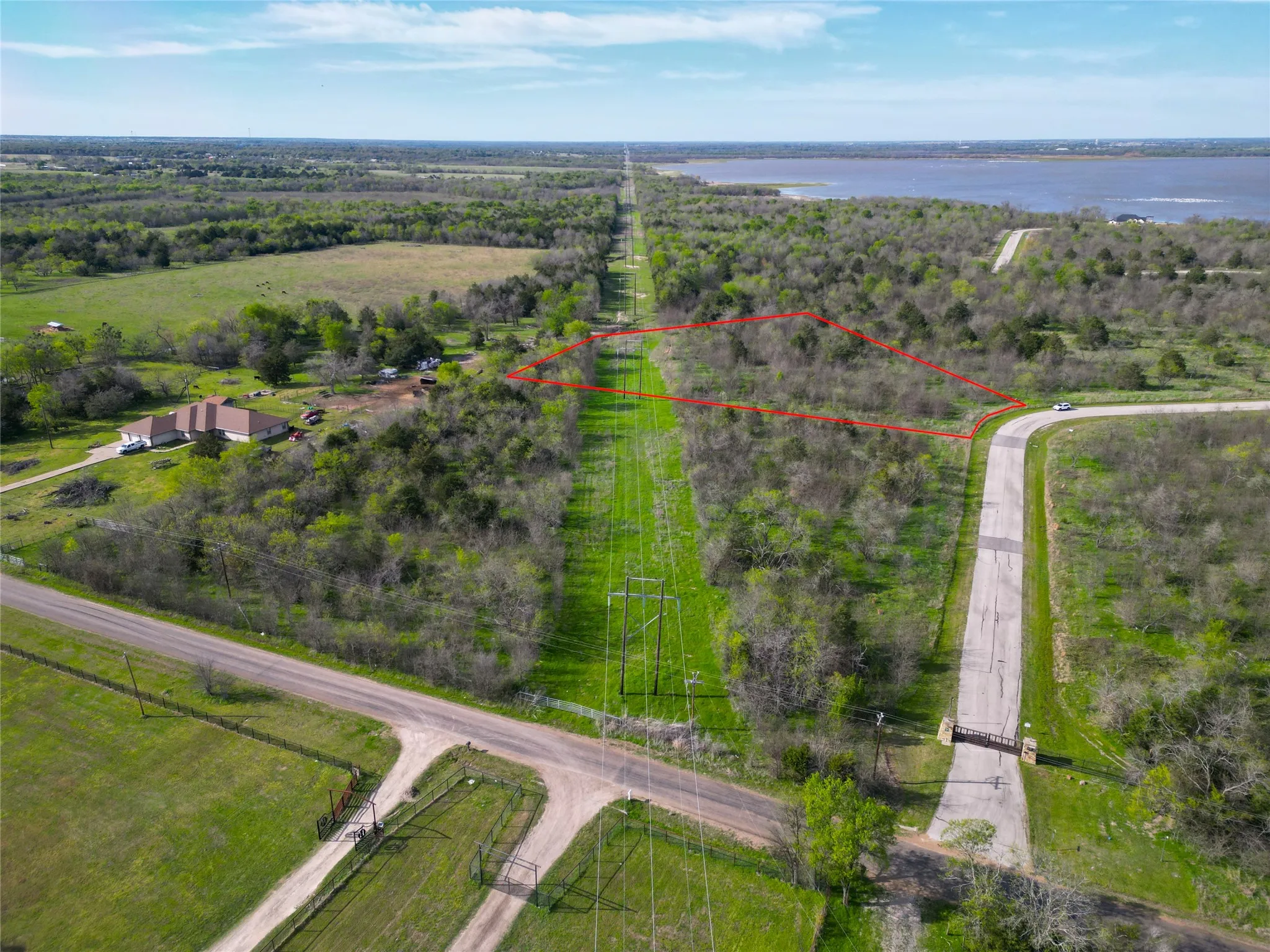 Expansive acreage featuring abundant natural foliage and a visible water body in the background
