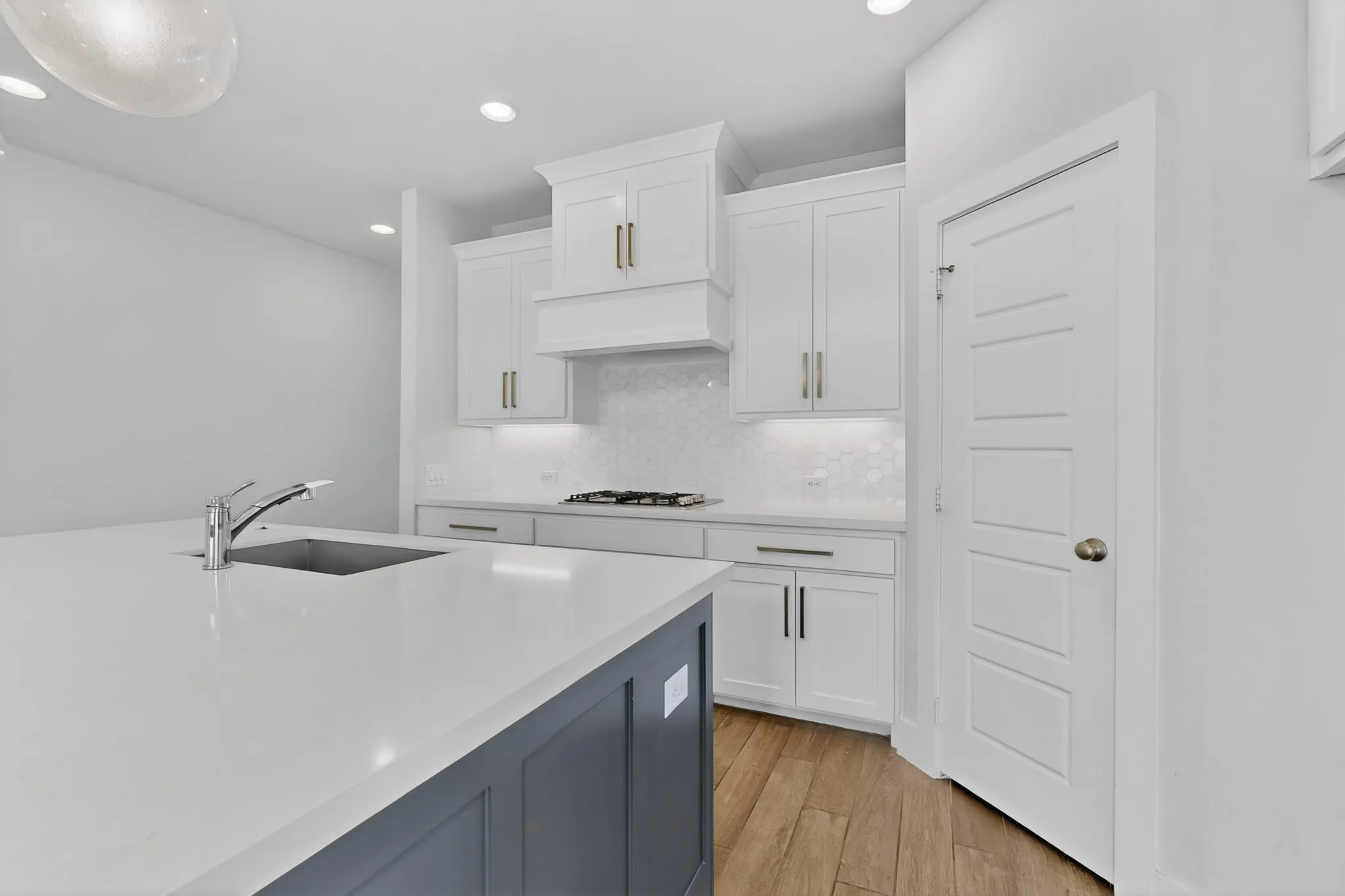 Spacious kitchen with a large island featuring a stainless steel sink and a modern faucet