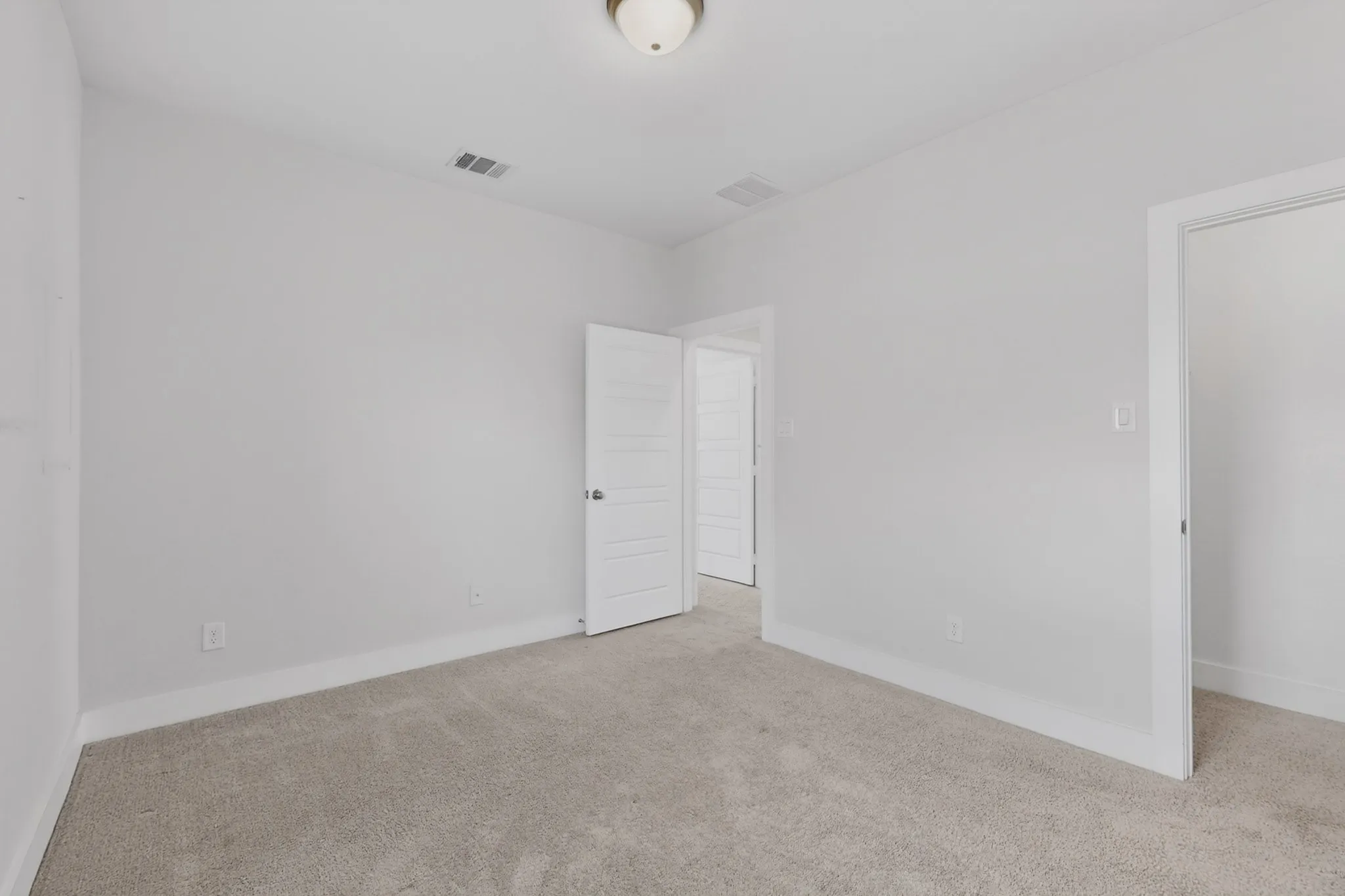 Carpeted room with light neutral walls