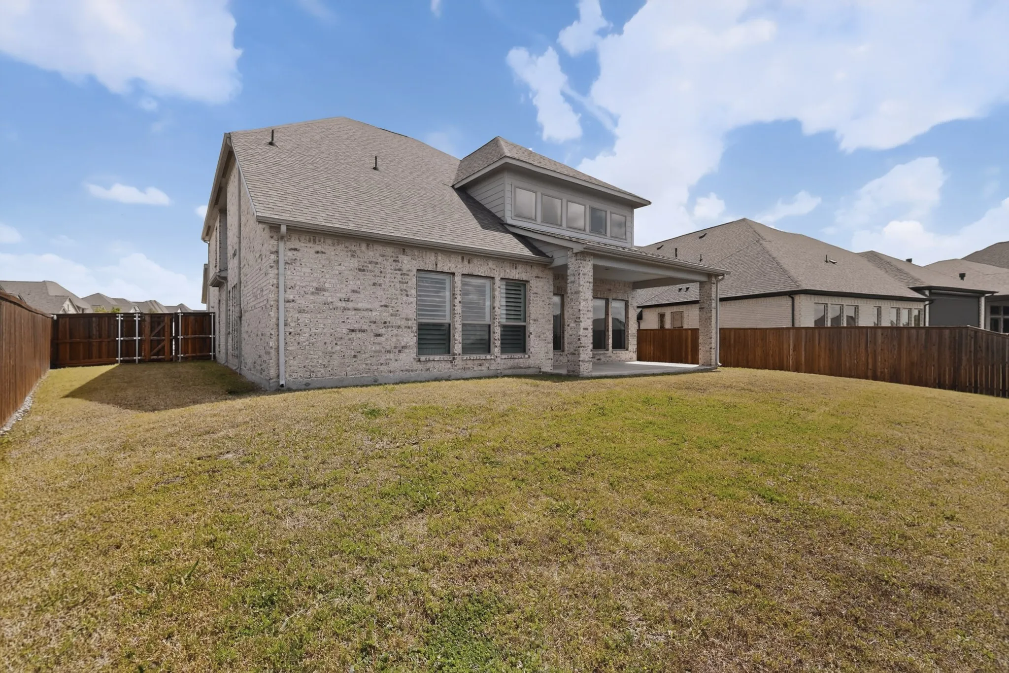 Expansive backyard featuring a manicured lawn and wood fencing