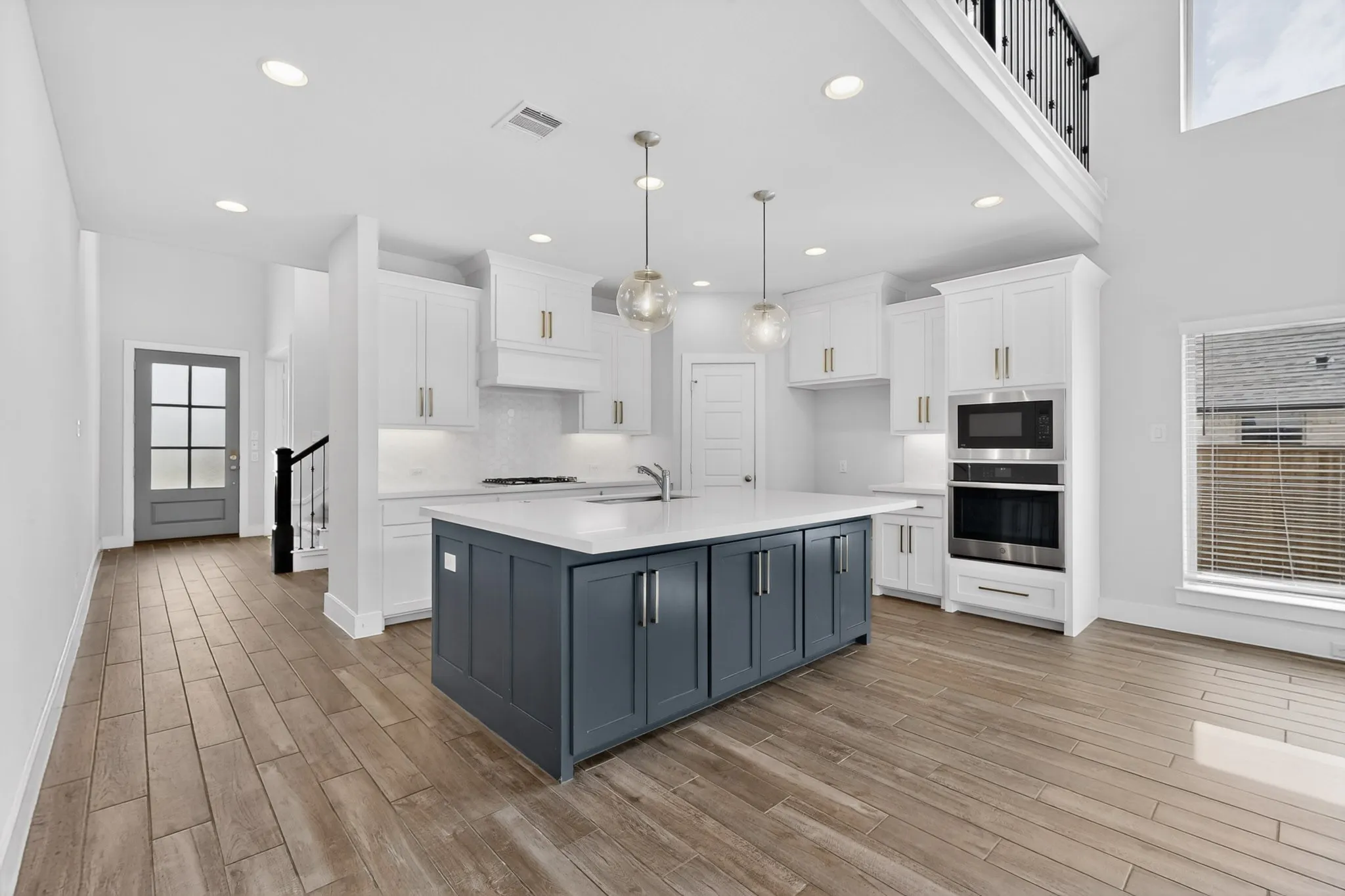 Spacious kitchen featuring a large central island with dark blue cabinetry and light countertops