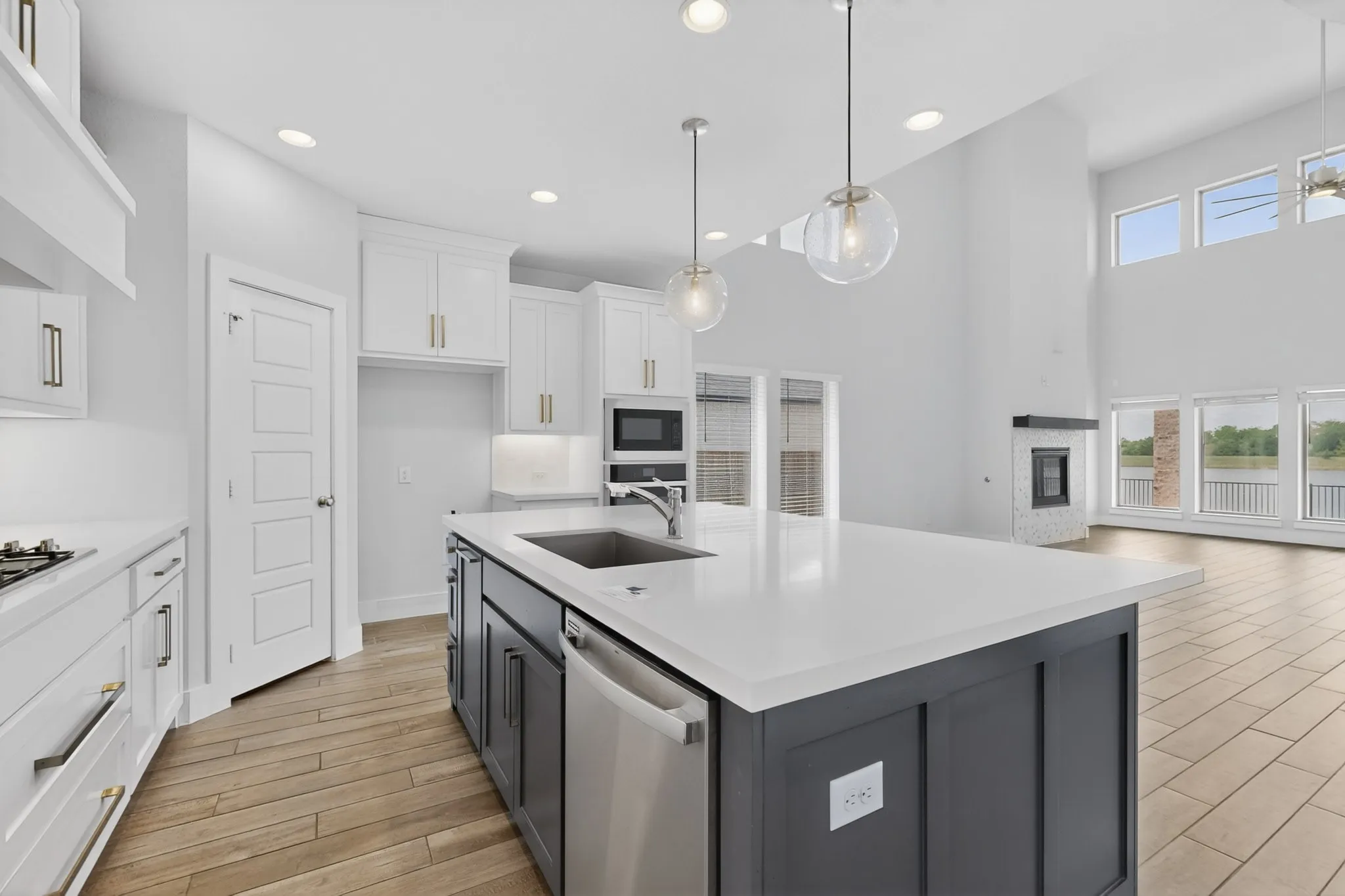 Expansive kitchen island with a white countertop and integrated sink, complemented by pendant lighting