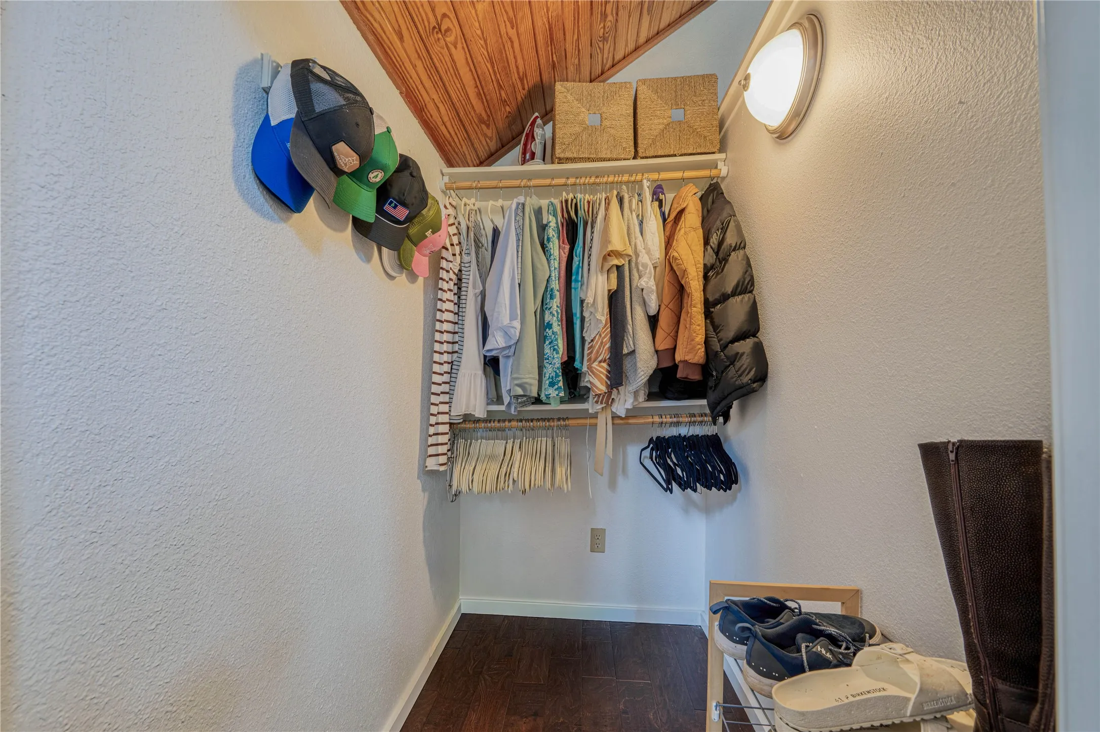 Interior closet space featuring wood-finish flooring and white textured walls