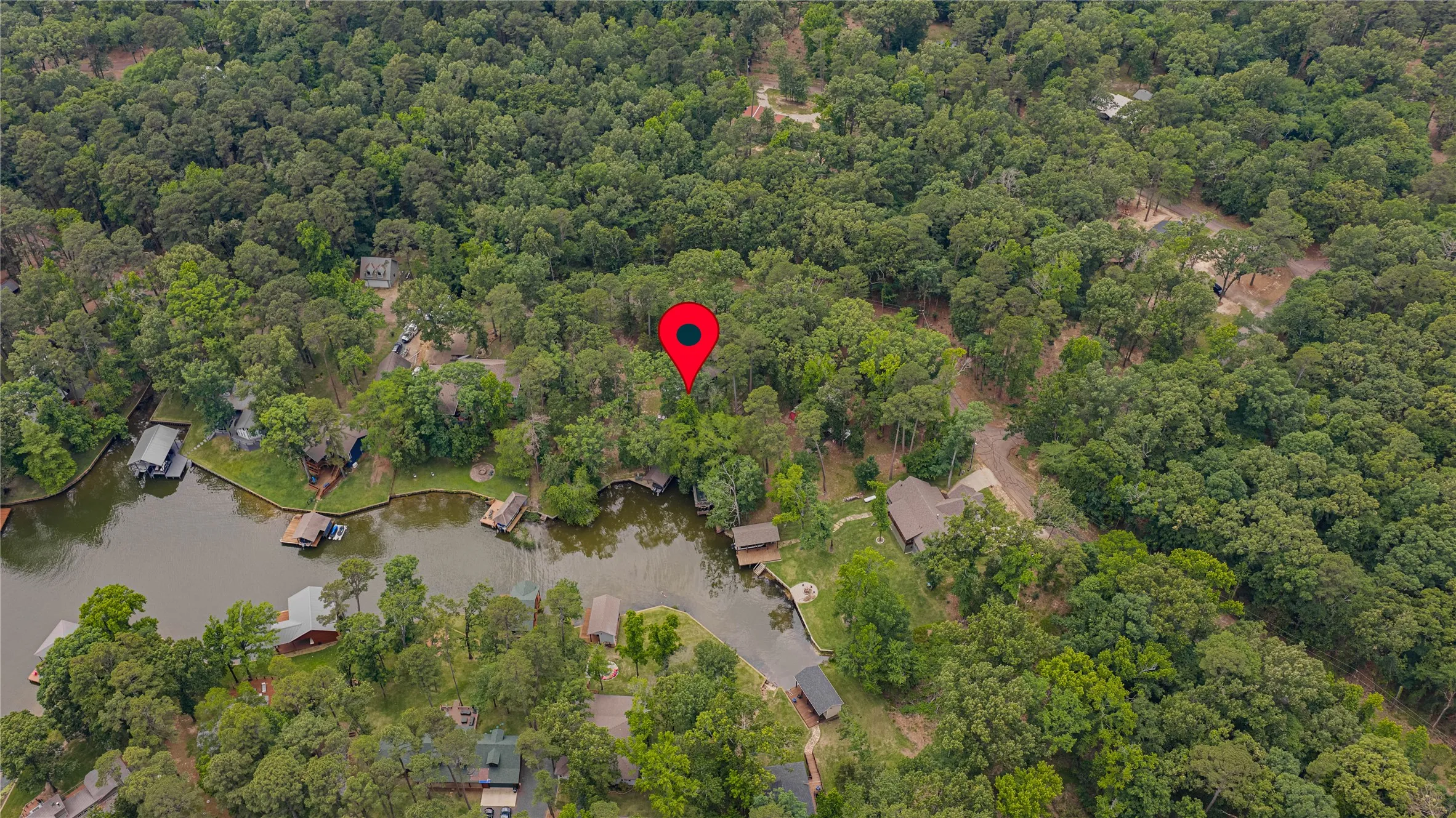 Aerial perspective of a waterfront property, showcasing extensive natural tree coverage