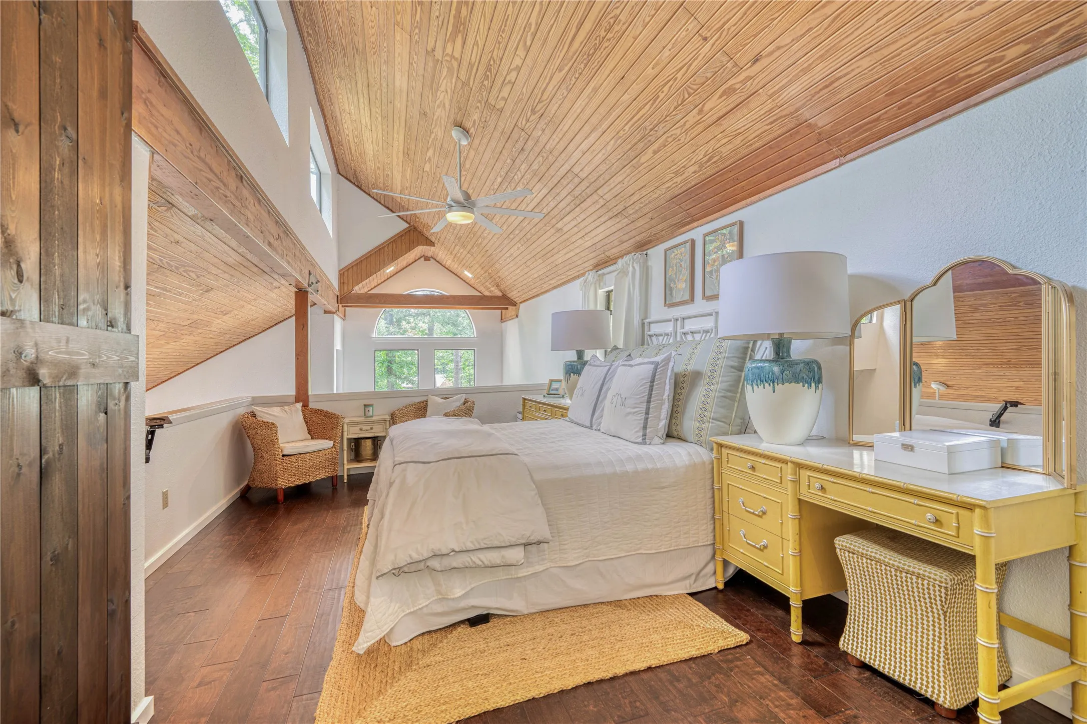 Vaulted wood-paneled ceiling with exposed beams, wood-finish flooring, and white walls