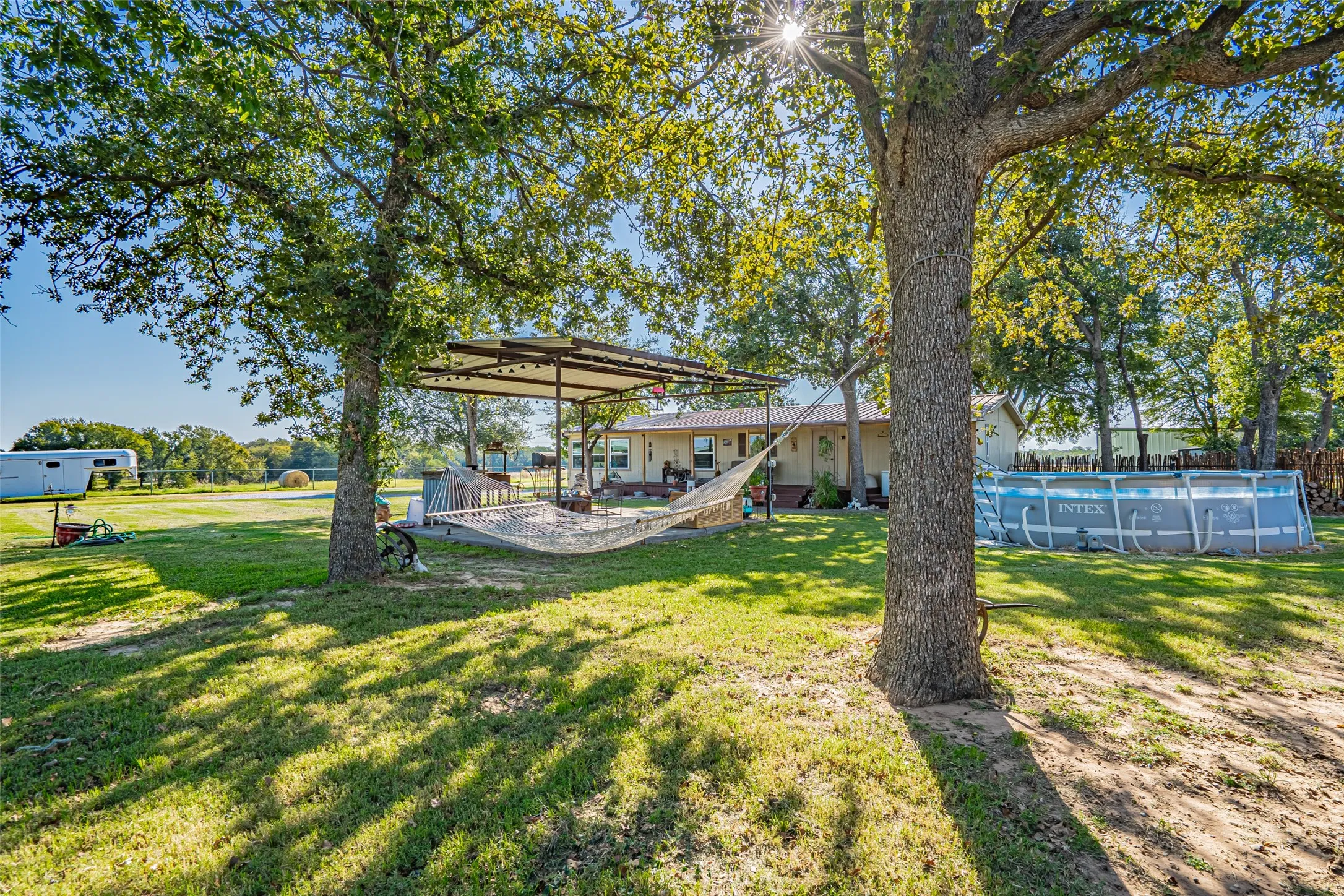 View of green lawn with an outdoor living space and a deck. Pool has been removed.