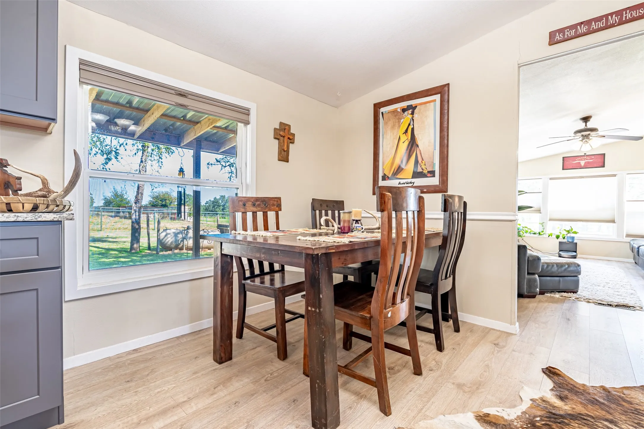 Dining area featuring vaulted ceiling, healthy amount of natural light, light wood-type flooring, and a ceiling fan.