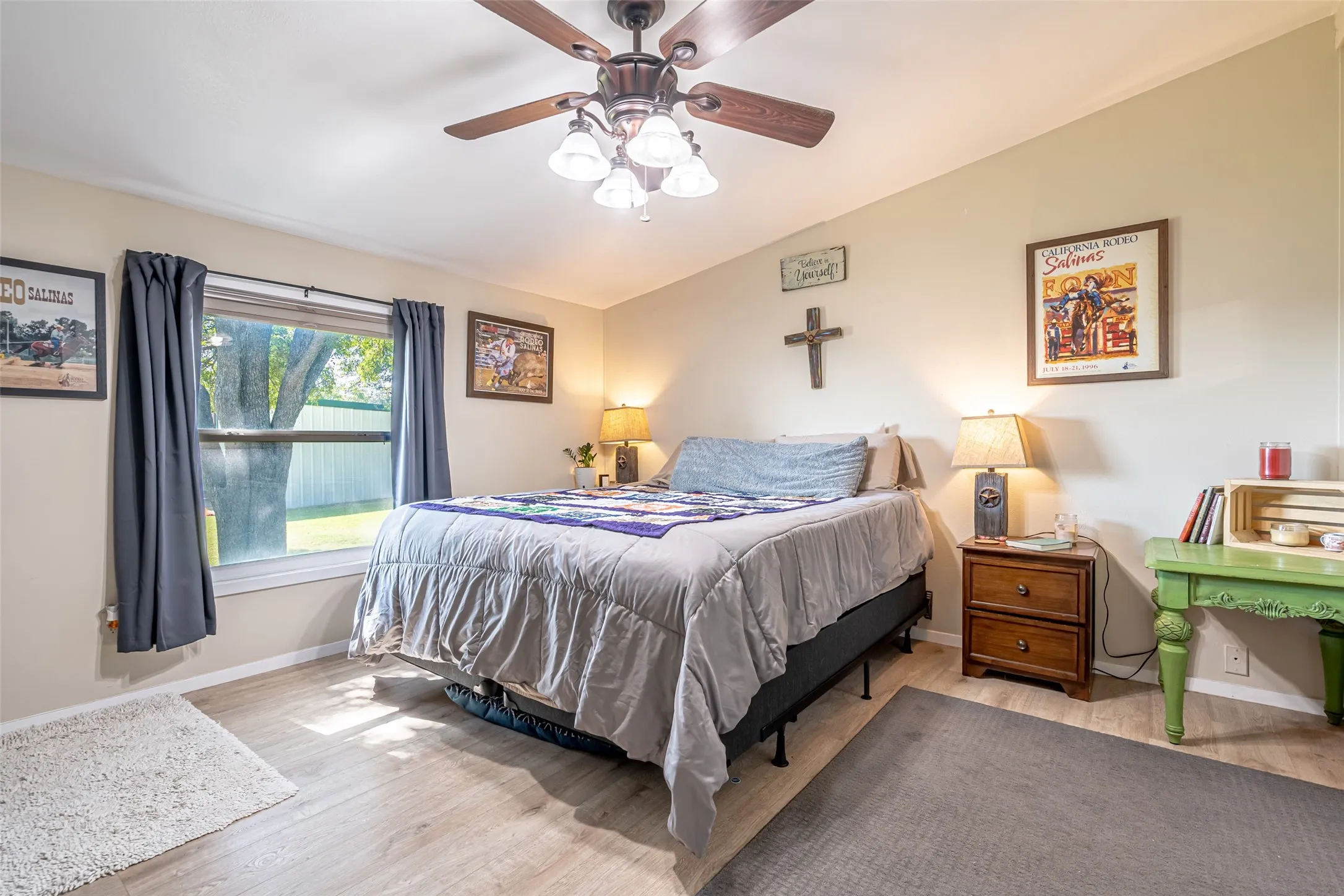 Primary Bedroom with wood look floors, vaulted ceiling, and ceiling fan.