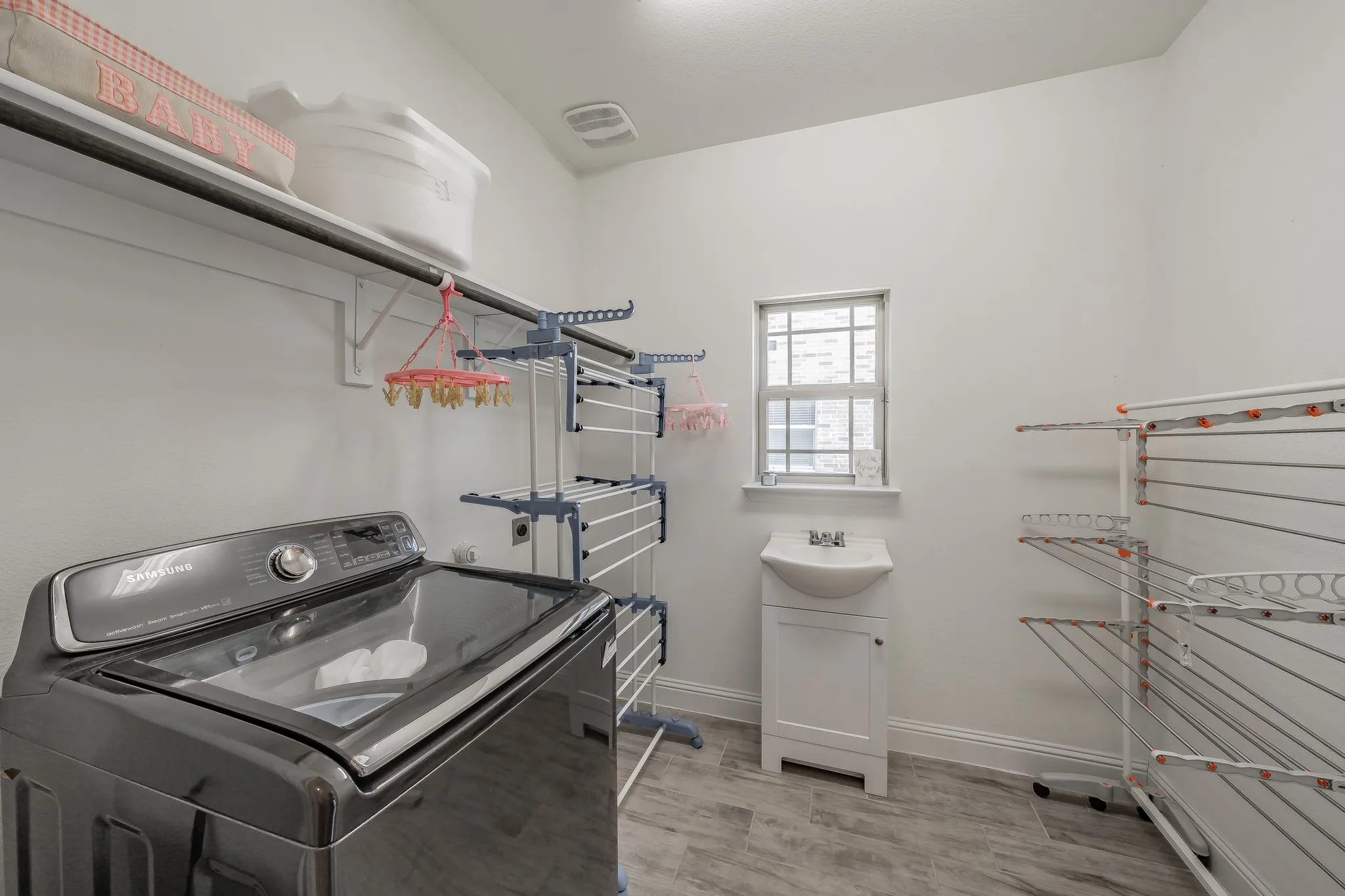 Laundry room has a sink and plenty of room for a freezer or extra fridge.