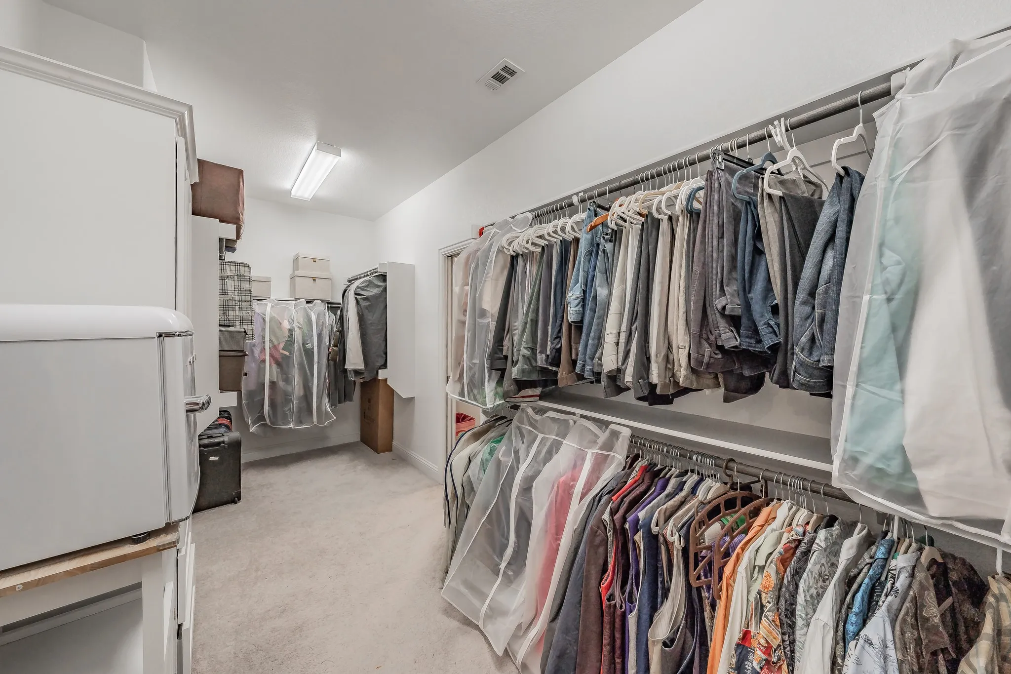 Spacious closet featuring light colored carpet