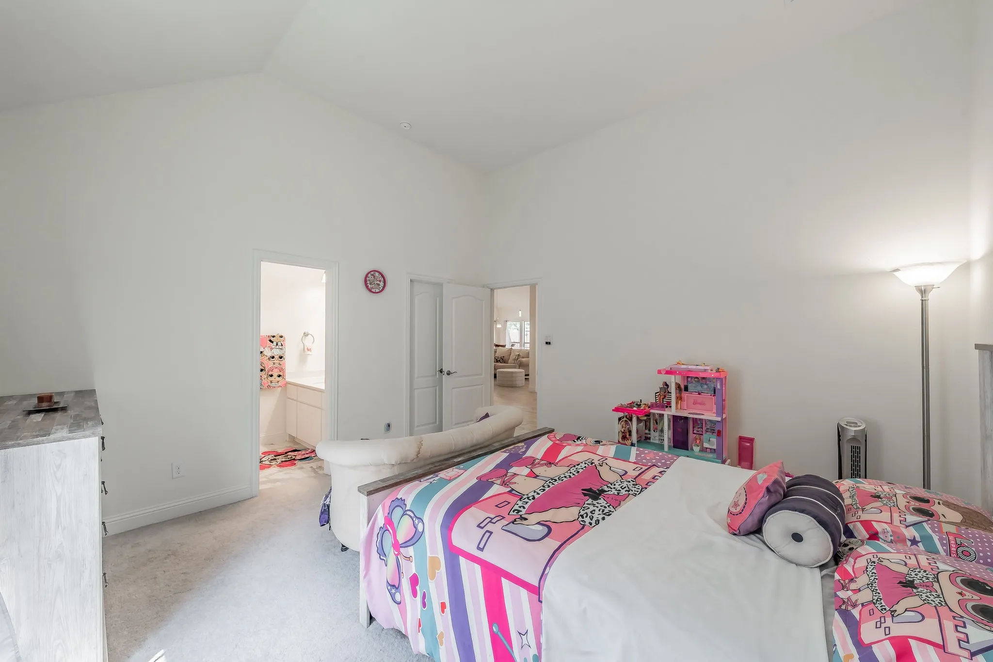 Carpeted bedroom with lofted ceiling and ensuite bathroom