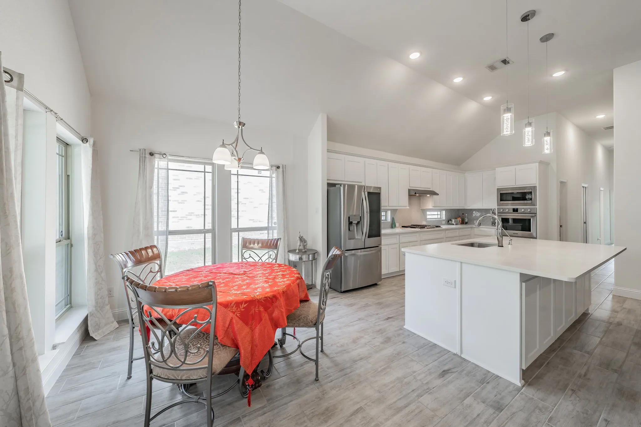 Kitchen featuring stainless steel appliances, an island with sink, and breakfast nook