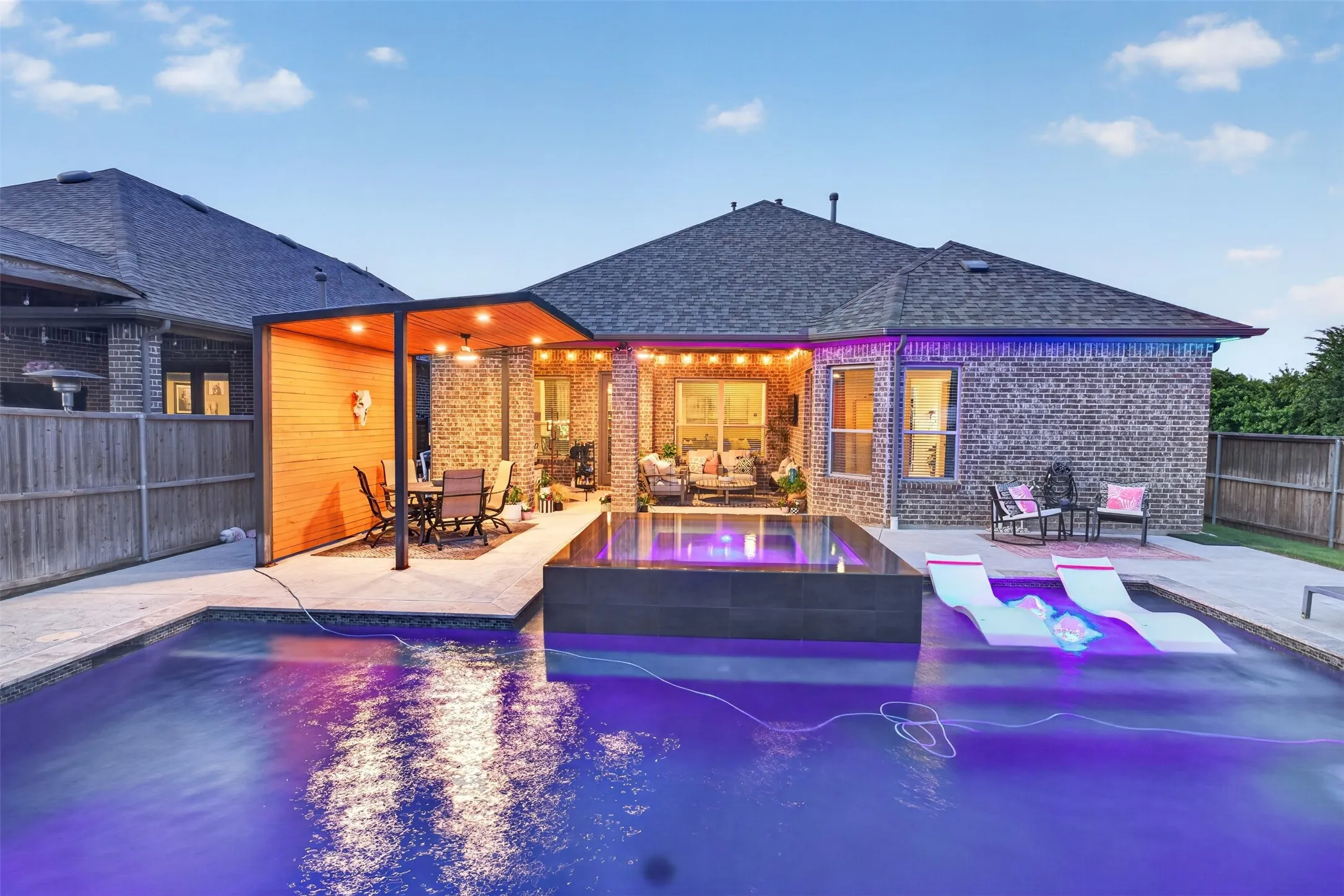 Waterfall spa, sun shelf and pool lighting create a true resort-style setting.