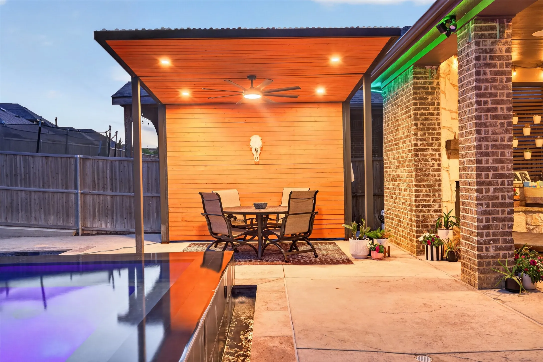 Covered patio overlooks the pool and provides additional space for outdoor dining and entertaining.