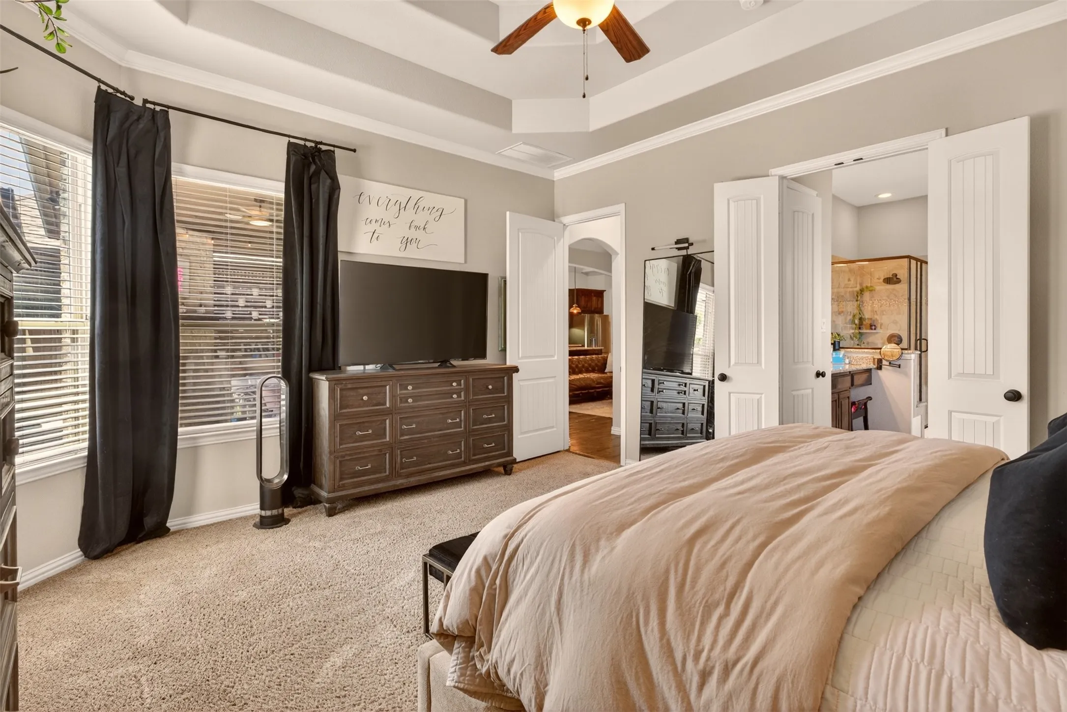 Primary suite offers generous proportions, wood flooring and abundant natural light.