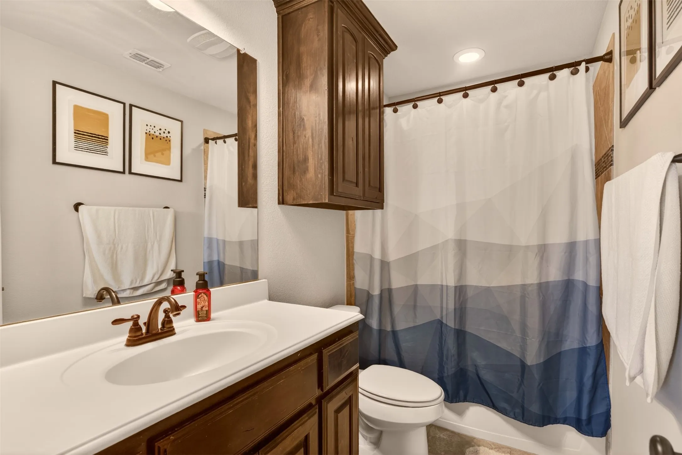 Full secondary bathroom features a tub-shower combination and ample vanity storage.