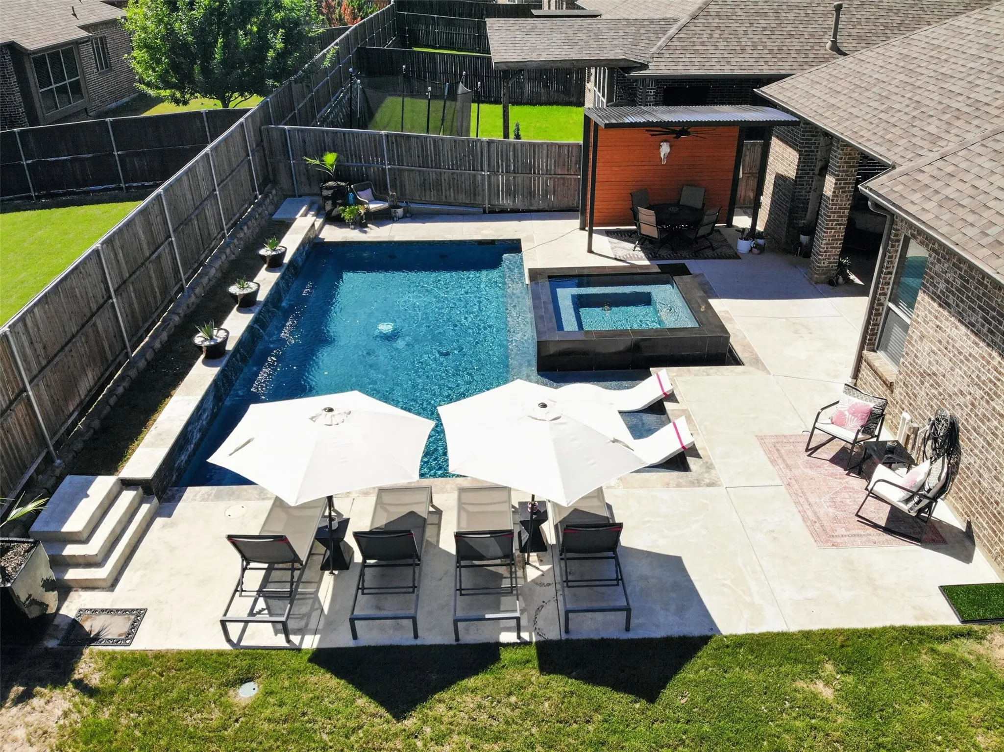 Aerial view highlights the pool, spa, sun shelf and spacious outdoor living areas.