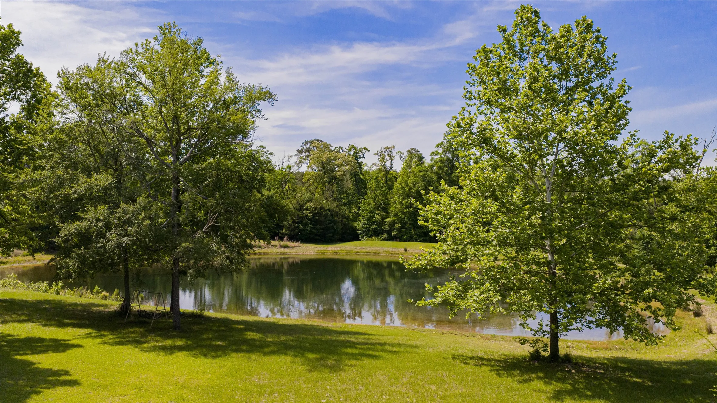 Private stocked pond surrounded by mature trees and lush green lawn- fishing, swimming, kayaking all take place on this 18' deep pond - Lots of memories left to be made here!
