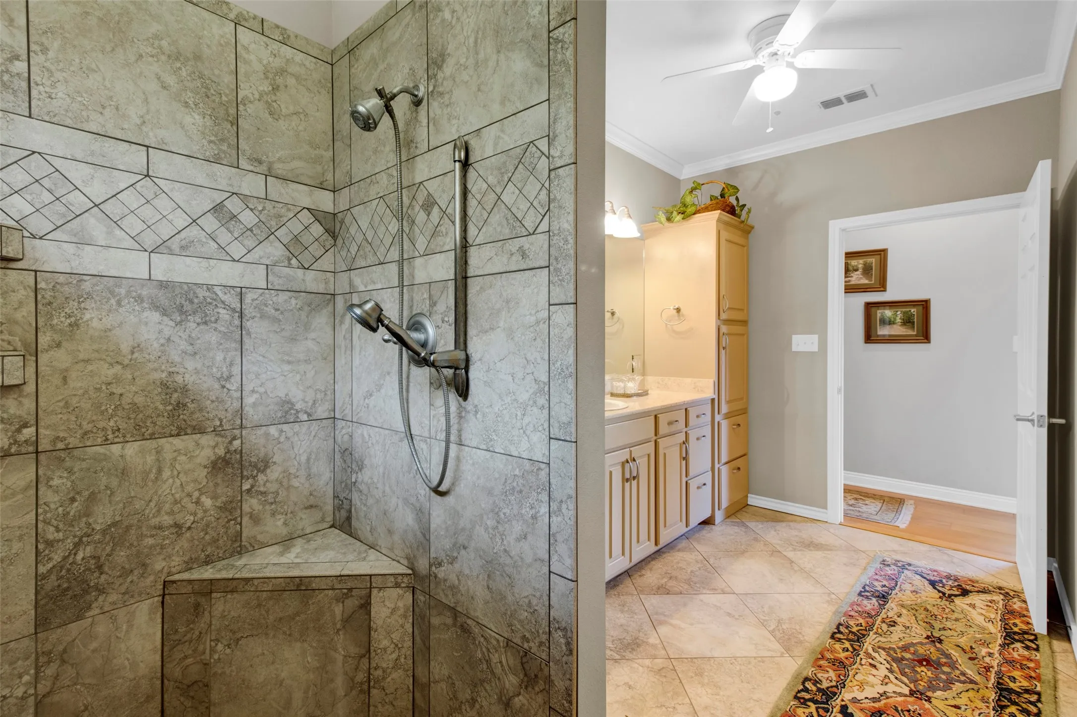 Tiled walk-in shower featuring a fixed showerhead, handheld shower, and integrated corner bench