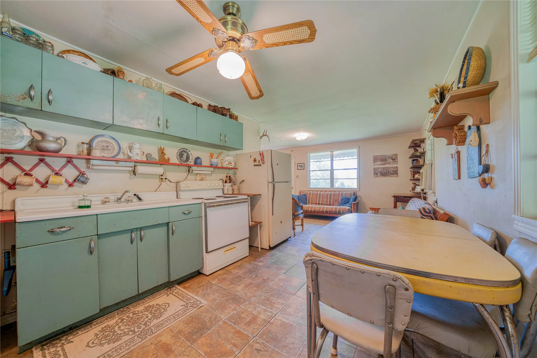 Cottage Functional kitchen featuring turquoise cabinetry, white countertops, a built-in range, and a ceiling fan with light fixture