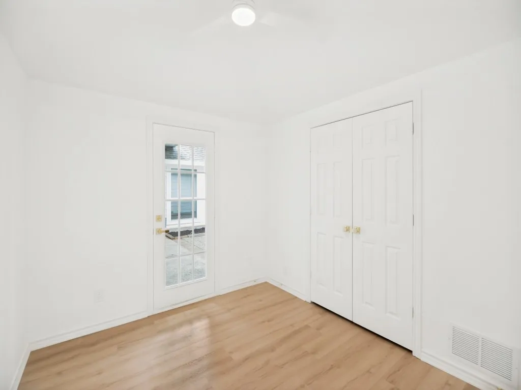 Room featuring light wood-finish flooring, white walls, and white trim