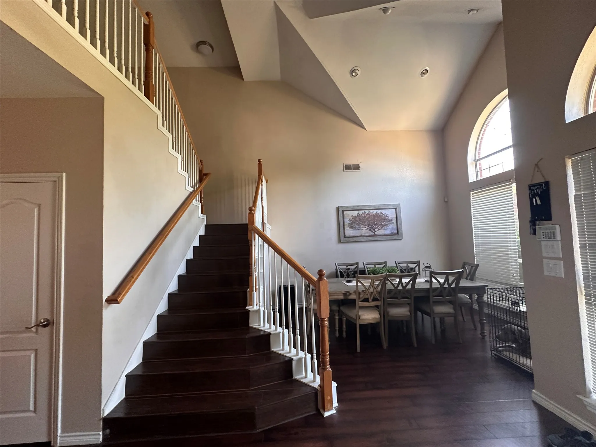 Grand entryway featuring a U-shaped staircase with wood-finish treads, white risers, and wood handrails