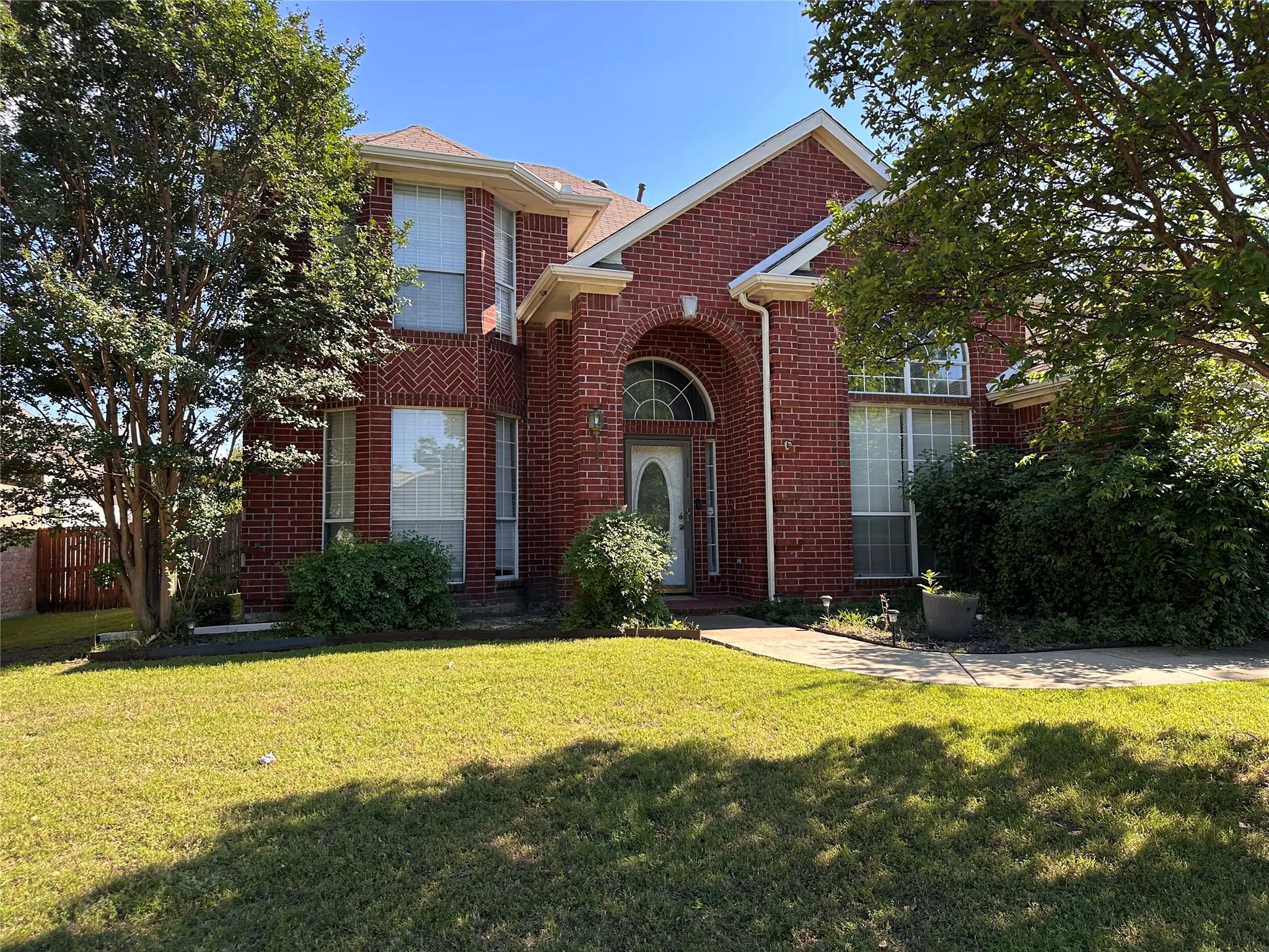 Red brick exterior featuring a prominent arched entry