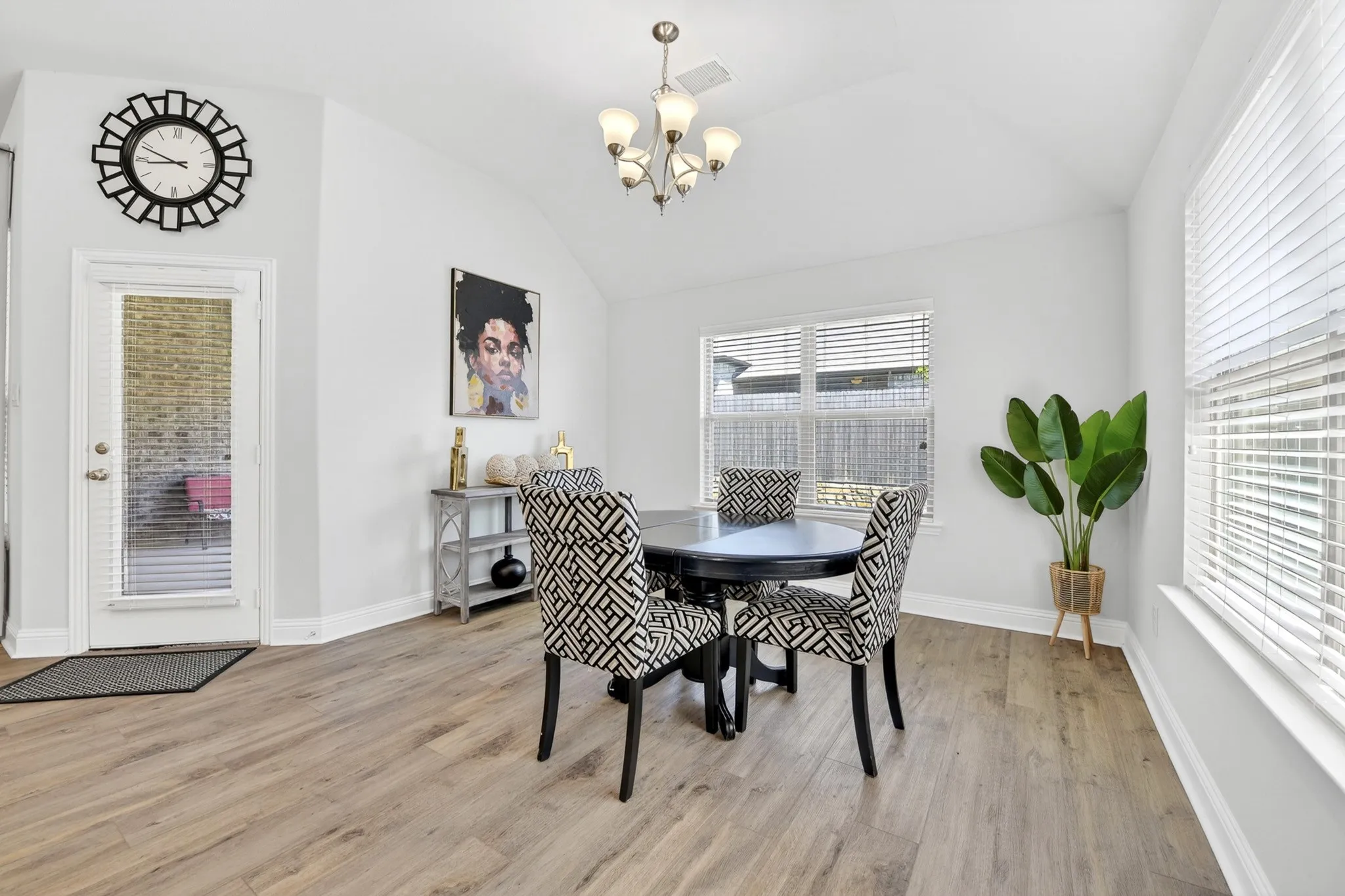 Vaulted ceiling room featuring light wood-finish flooring