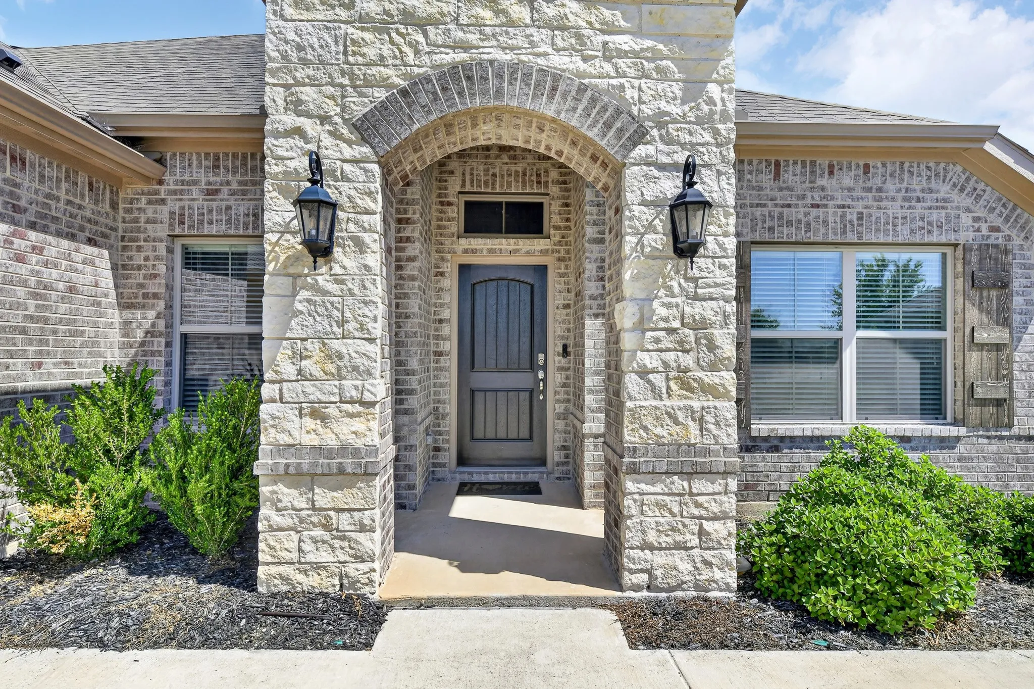 Stone and brick facade featuring an arched entryway