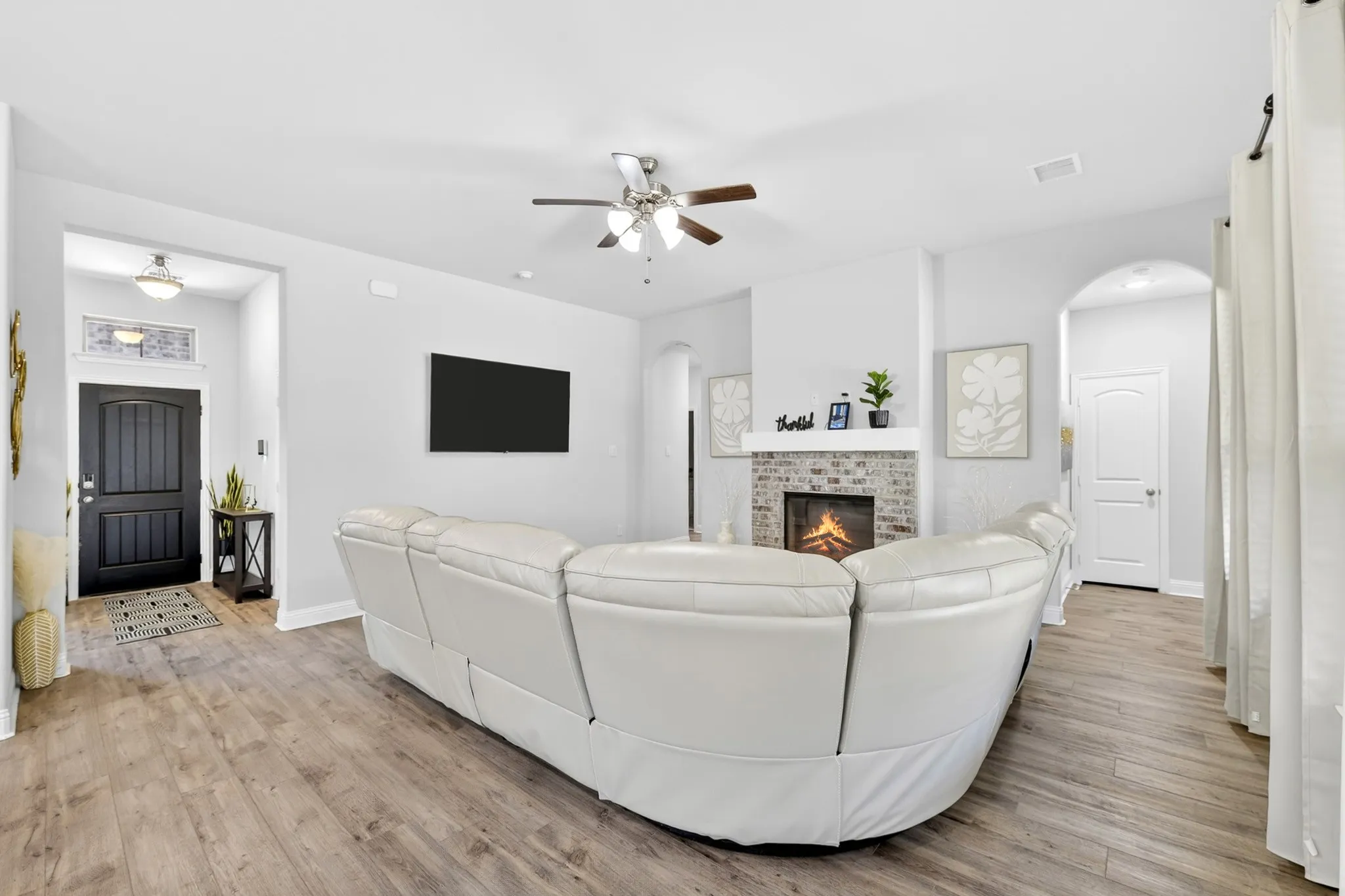 Spacious living area featuring wood-finish flooring and light gray wall tones