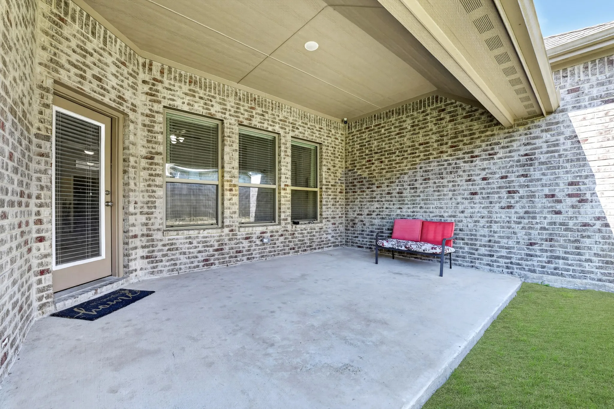 Covered patio featuring a concrete slab and brick exterior
