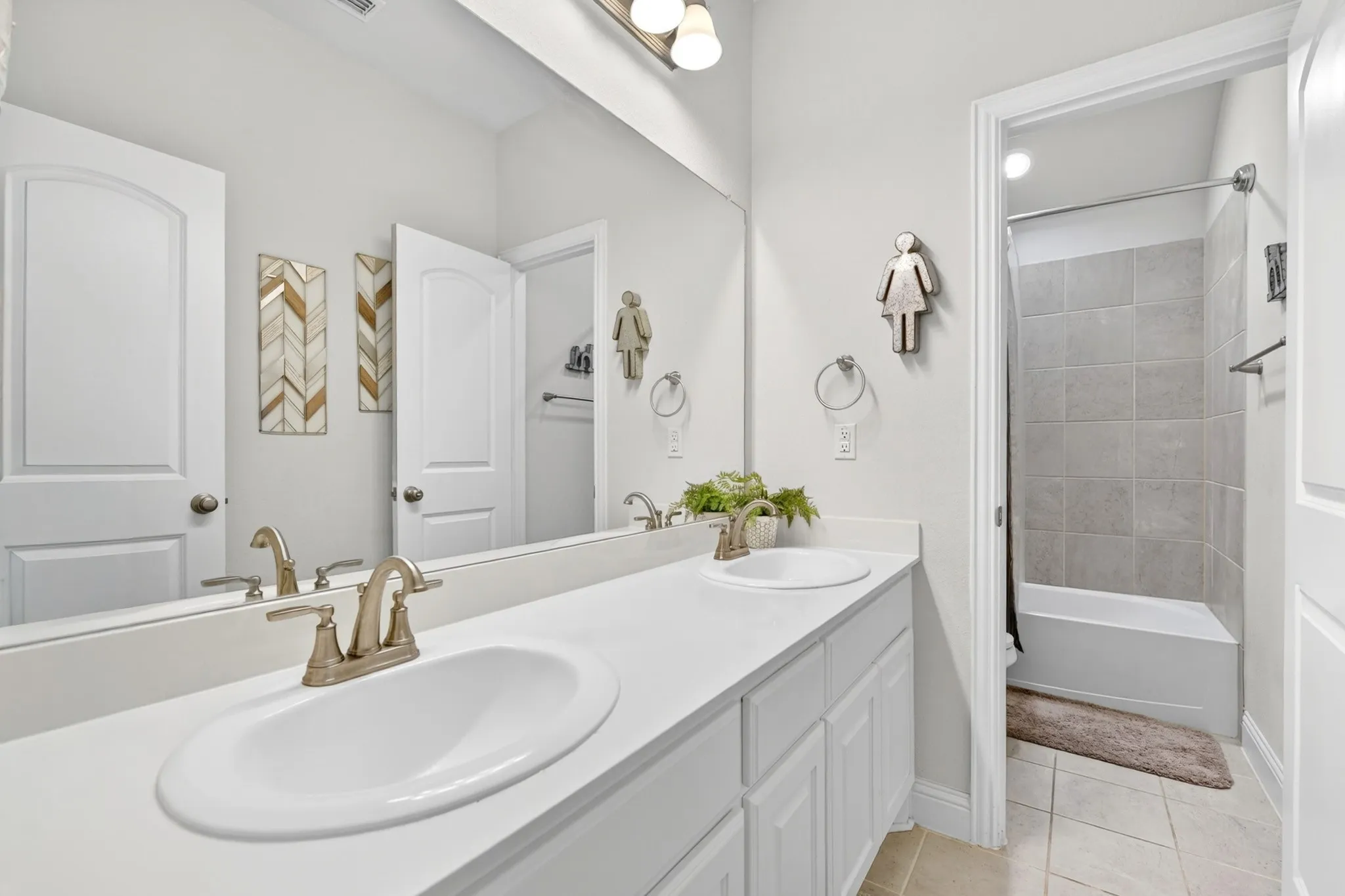 Double vanity with white cabinetry, integrated sinks, and brushed nickel fixtures