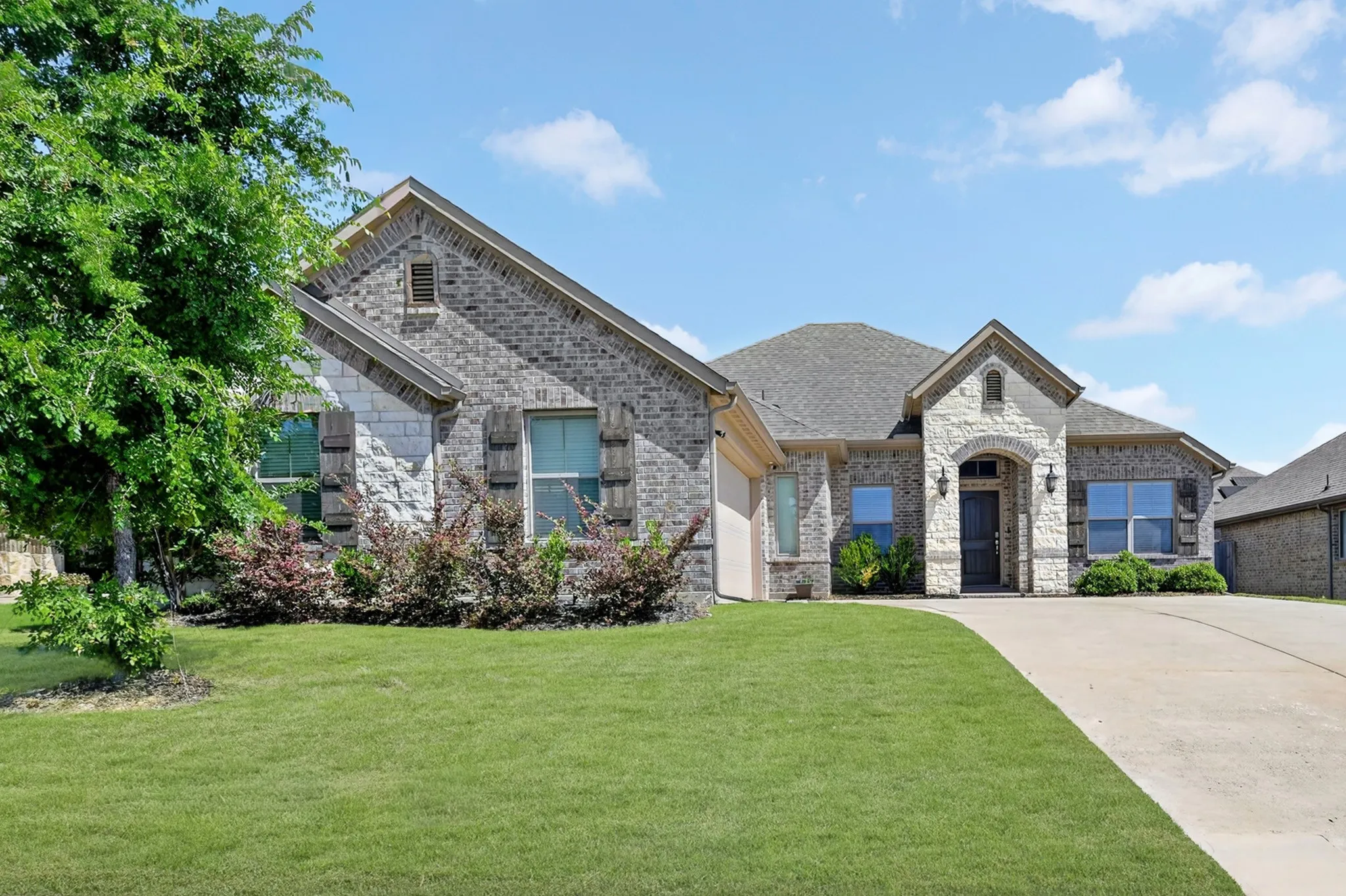 Brick and stone façade residence with a gabled entry