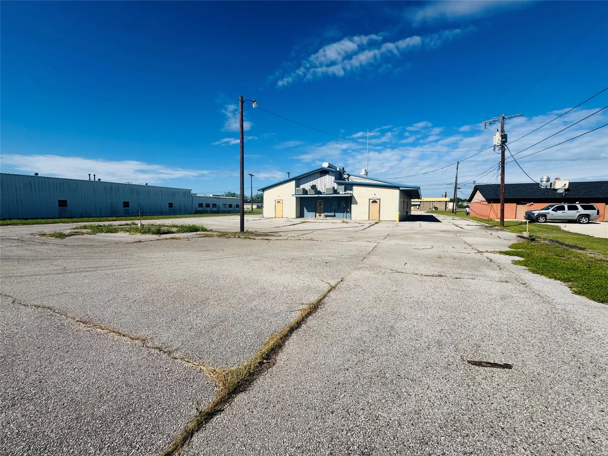 Expansive paved parking lot with multiple buildings on property