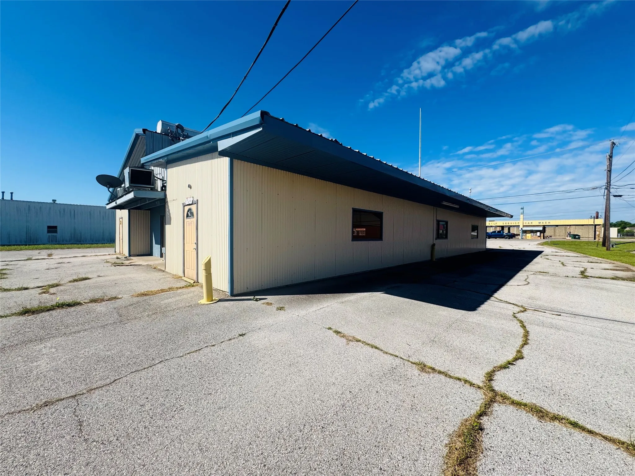Commercial building with light-colored corrugated siding and a blue metal roof