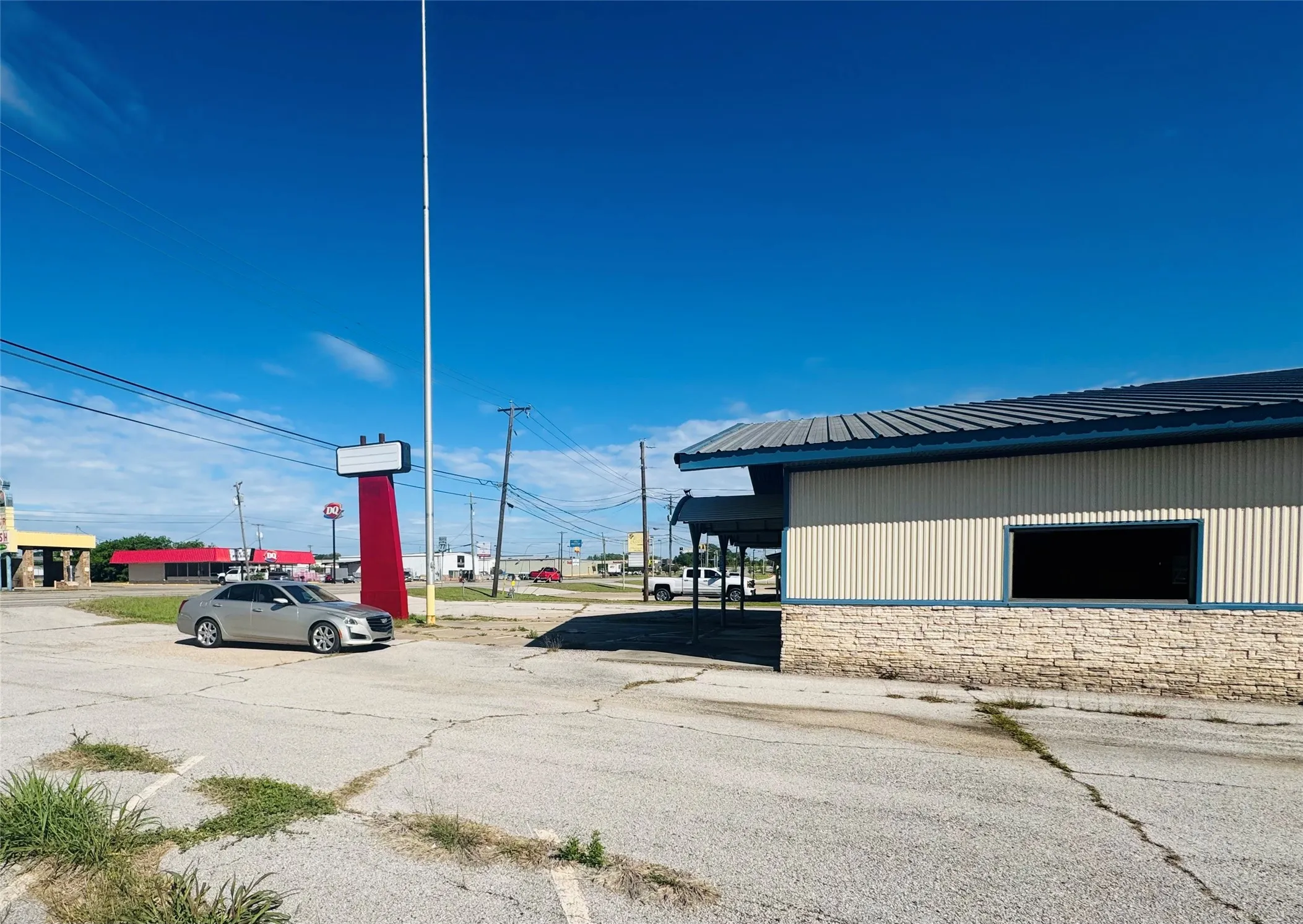 Commercial building featuring a metal roof, corrugated siding, and a stone facade