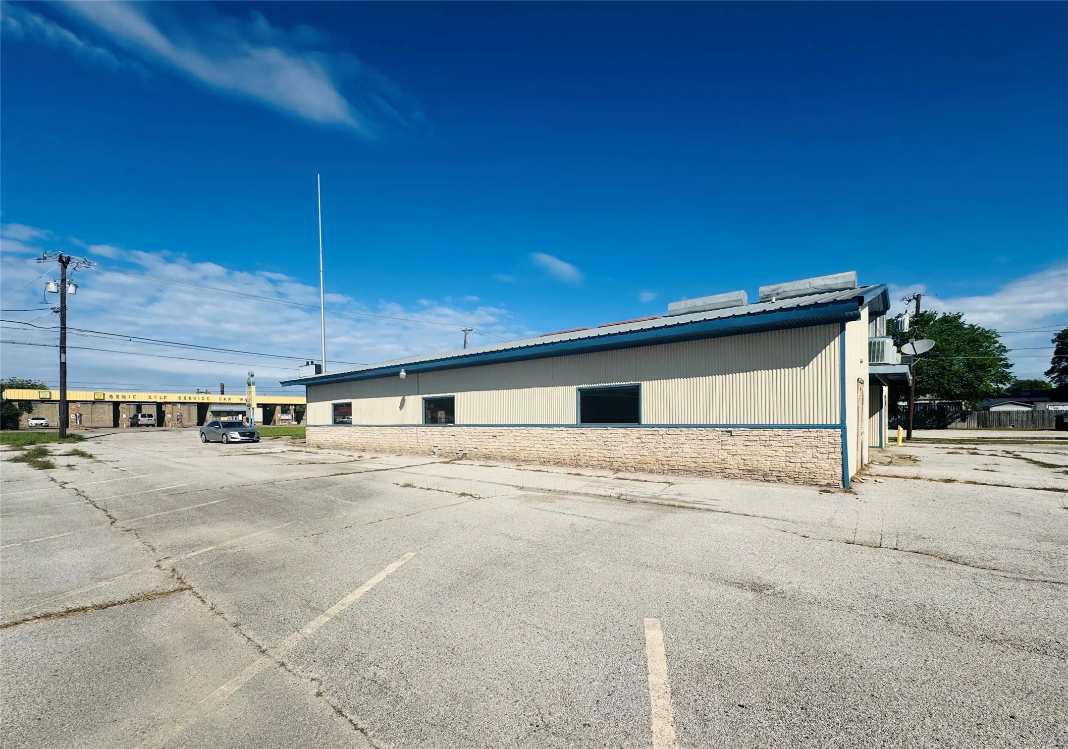 Commercial building with corrugated metal siding, stone veneer base, and a sloped metal roof