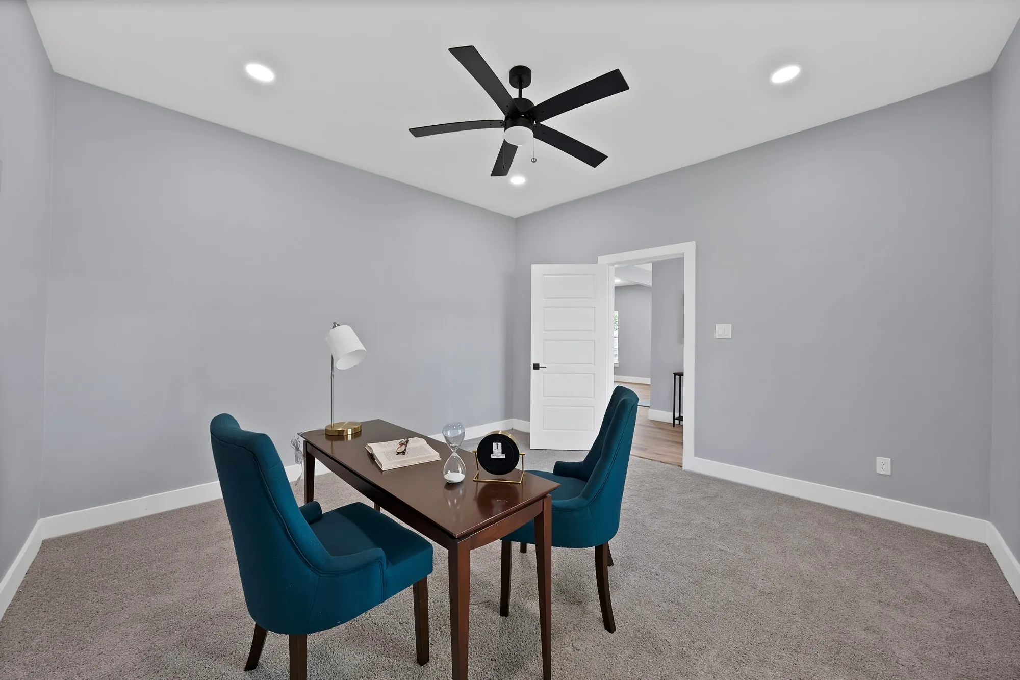 Room featuring light gray wall paint, gray carpet flooring, a modern black ceiling fan, and recessed lighting
