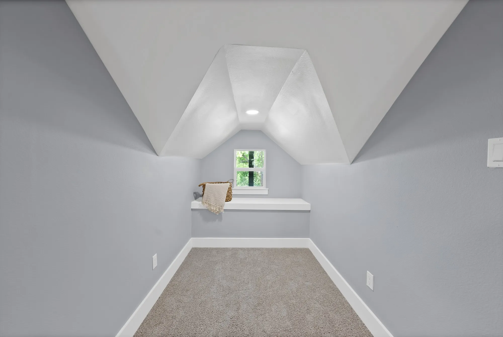 Attic space featuring sloped ceilings, a small window, built-in shelving, recessed lighting, and grey carpeting