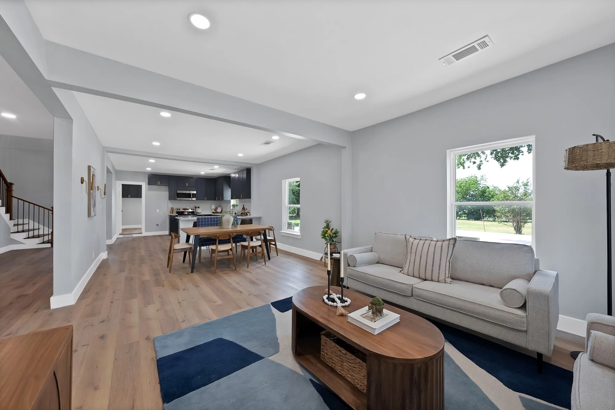 Open-concept living space featuring wood-finish flooring, recessed lighting, and a neutral color palette