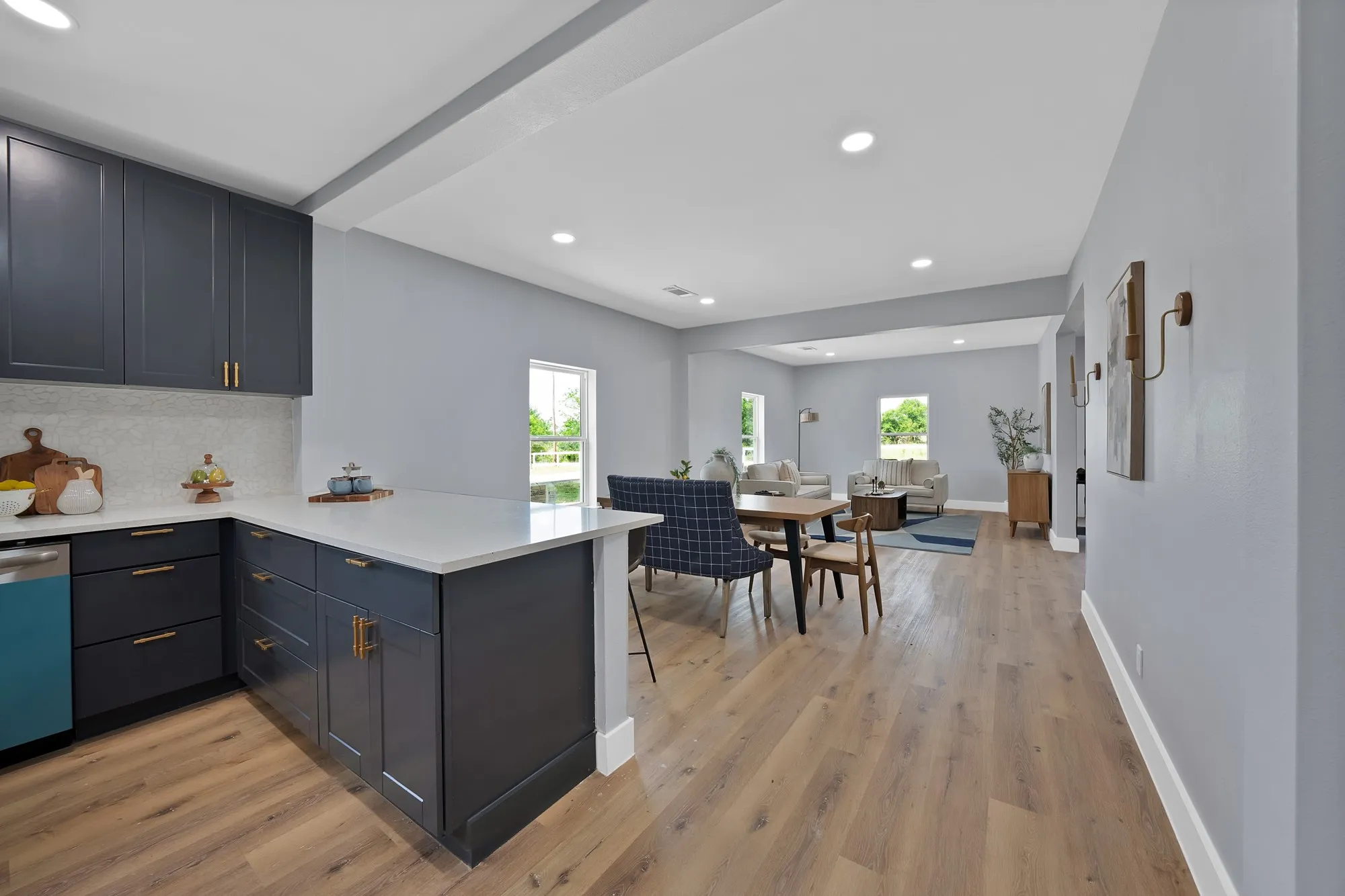 Kitchen featuring dark shaker-style cabinetry, white countertops, and a light-toned tile backsplash