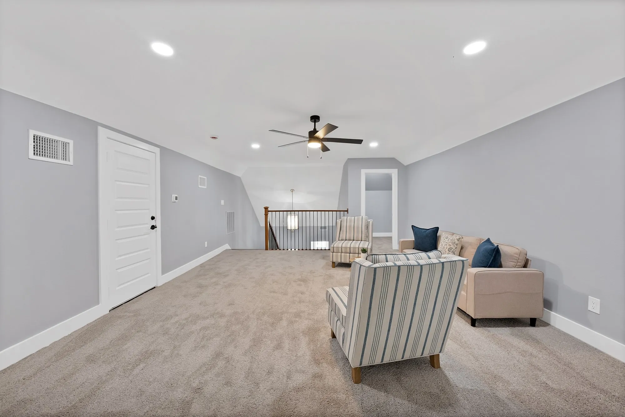 Spacious bonus room featuring neutral carpeting, light gray walls, white trim, recessed lighting, and a ceiling fan