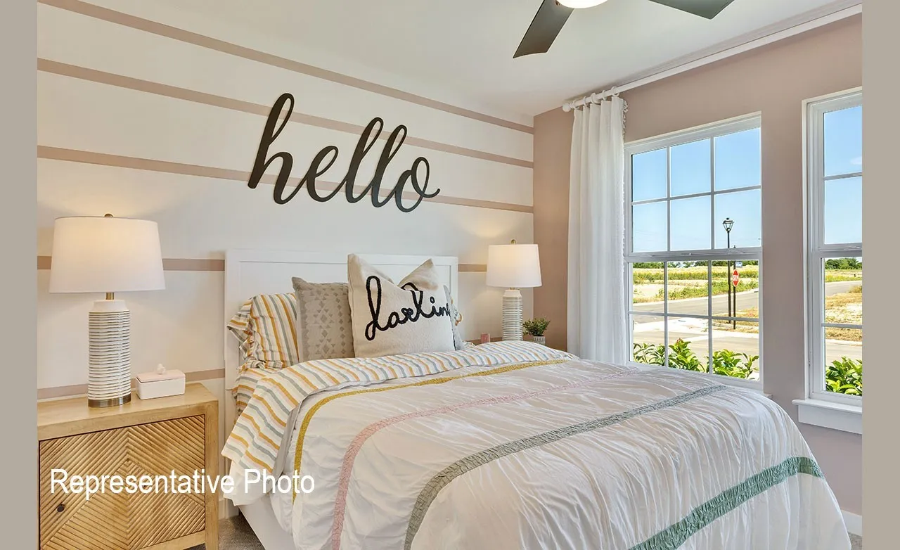Bedroom featuring two large single-hung windows with exterior grid patterns, a ceiling fan, and a light-toned wood-finish nightstand