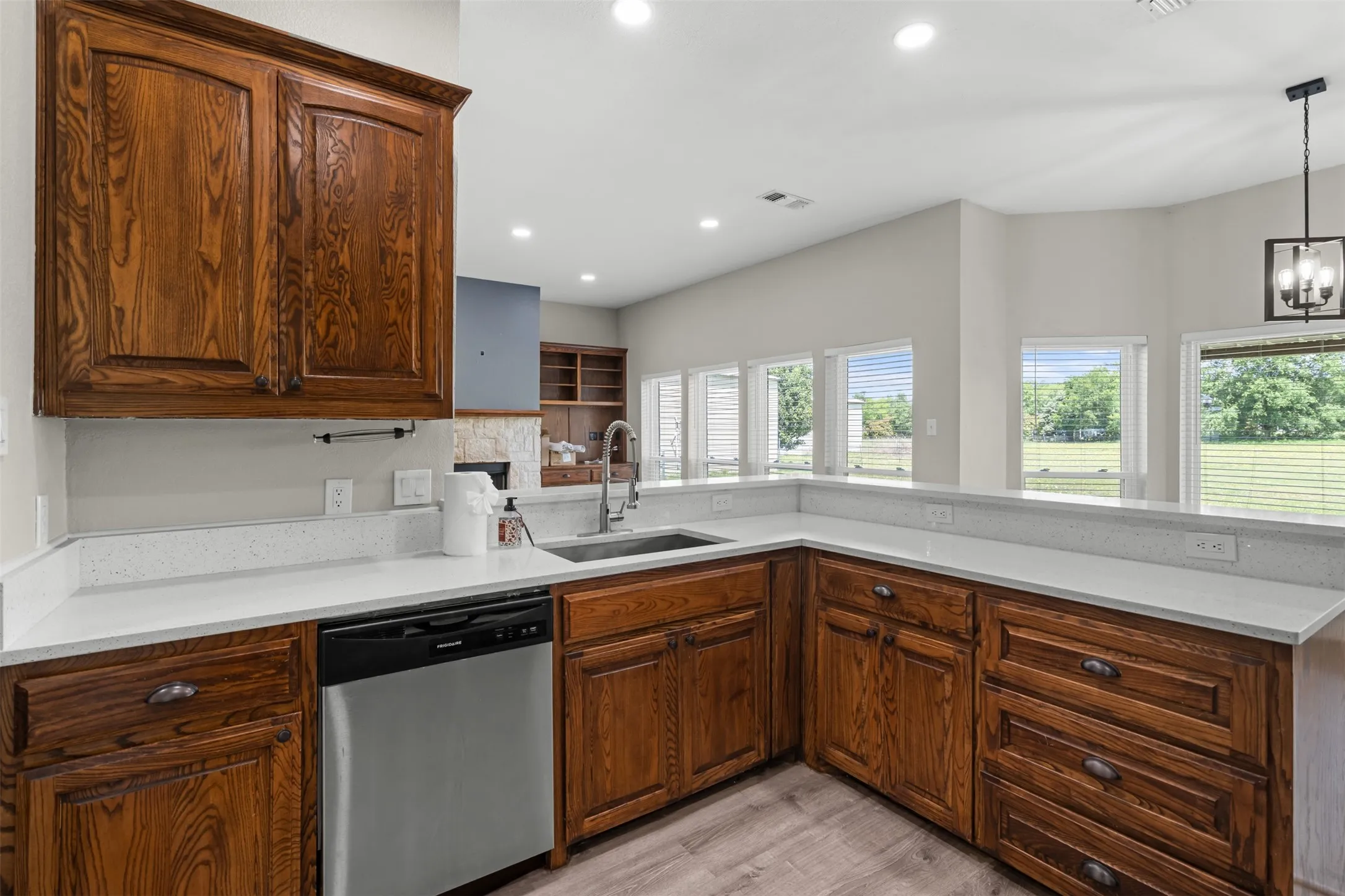 Kitchen featuring wood cabinetry, stainless steel sink, and light-toned countertops