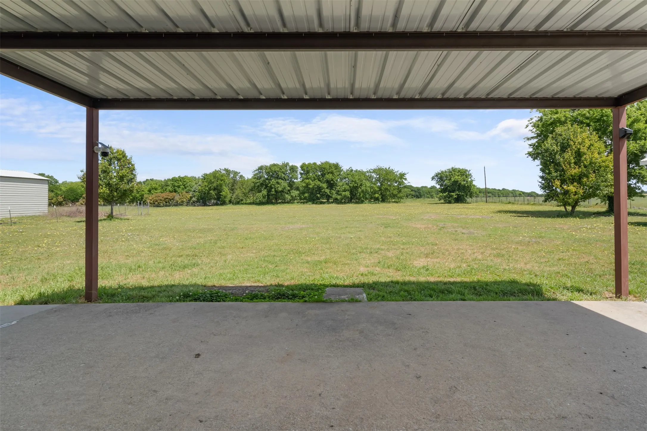 Concrete patio with an overhead metal roof structure