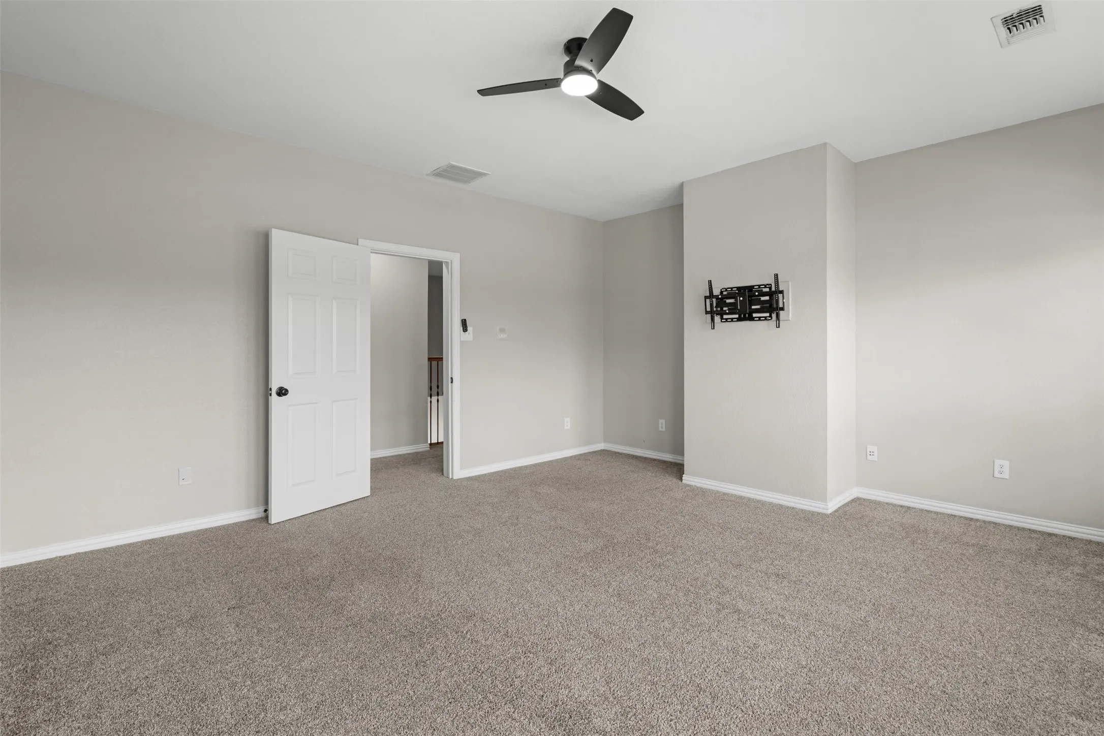 Expansive room featuring plush carpeting and neutral wall tones